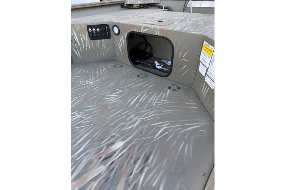 2025 Tracker Grizzly 1654 T Sportsman boat interior with camo pattern and storage compartment.