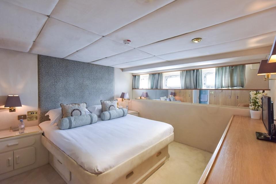 Luxurious bedroom interior on 1984 W.A. Souter & Sons yacht, featuring elegant decor and natural light.