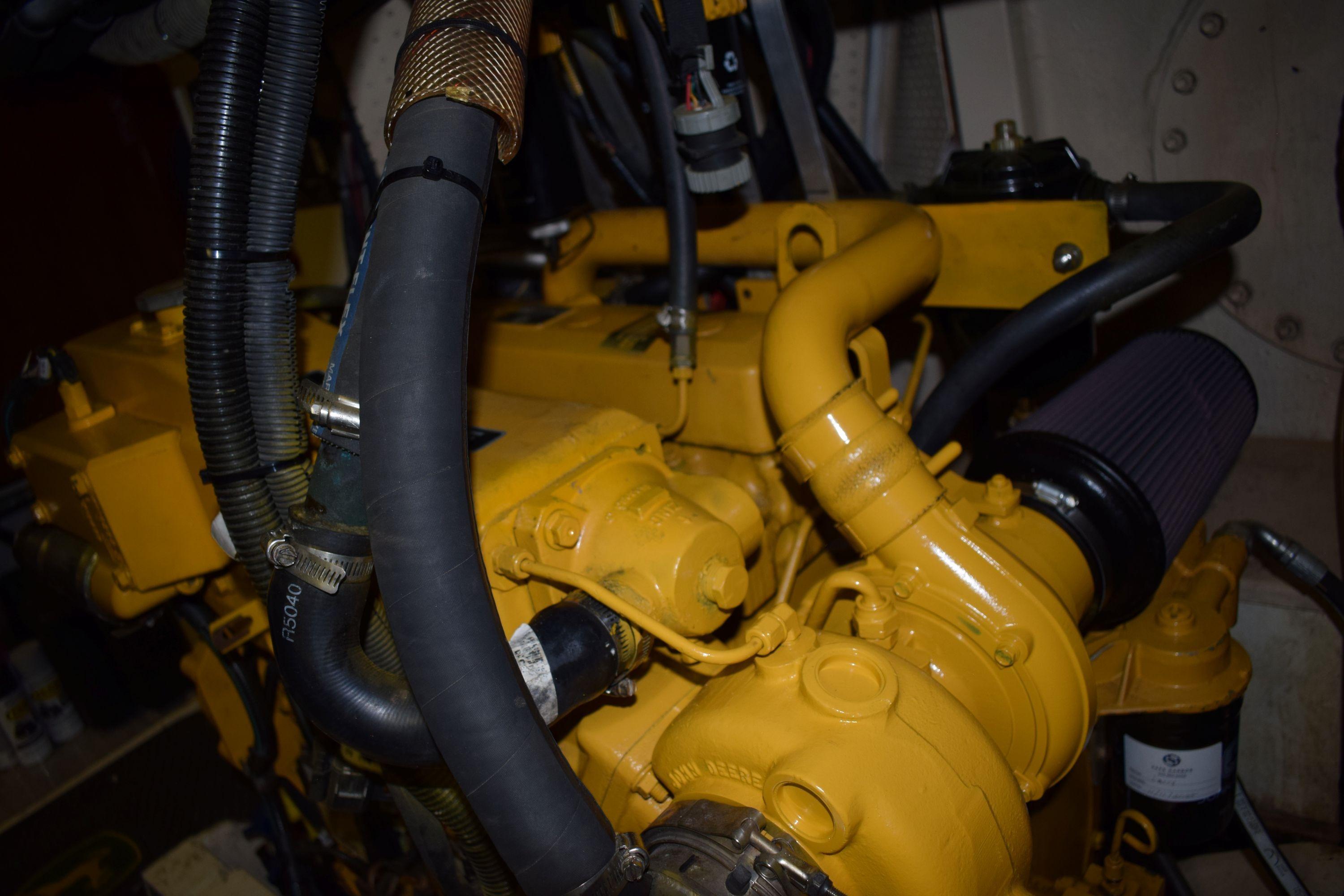 Engine of a 1980 Cheoy Lee 52 Motorsailer, showcasing yellow components and hoses.