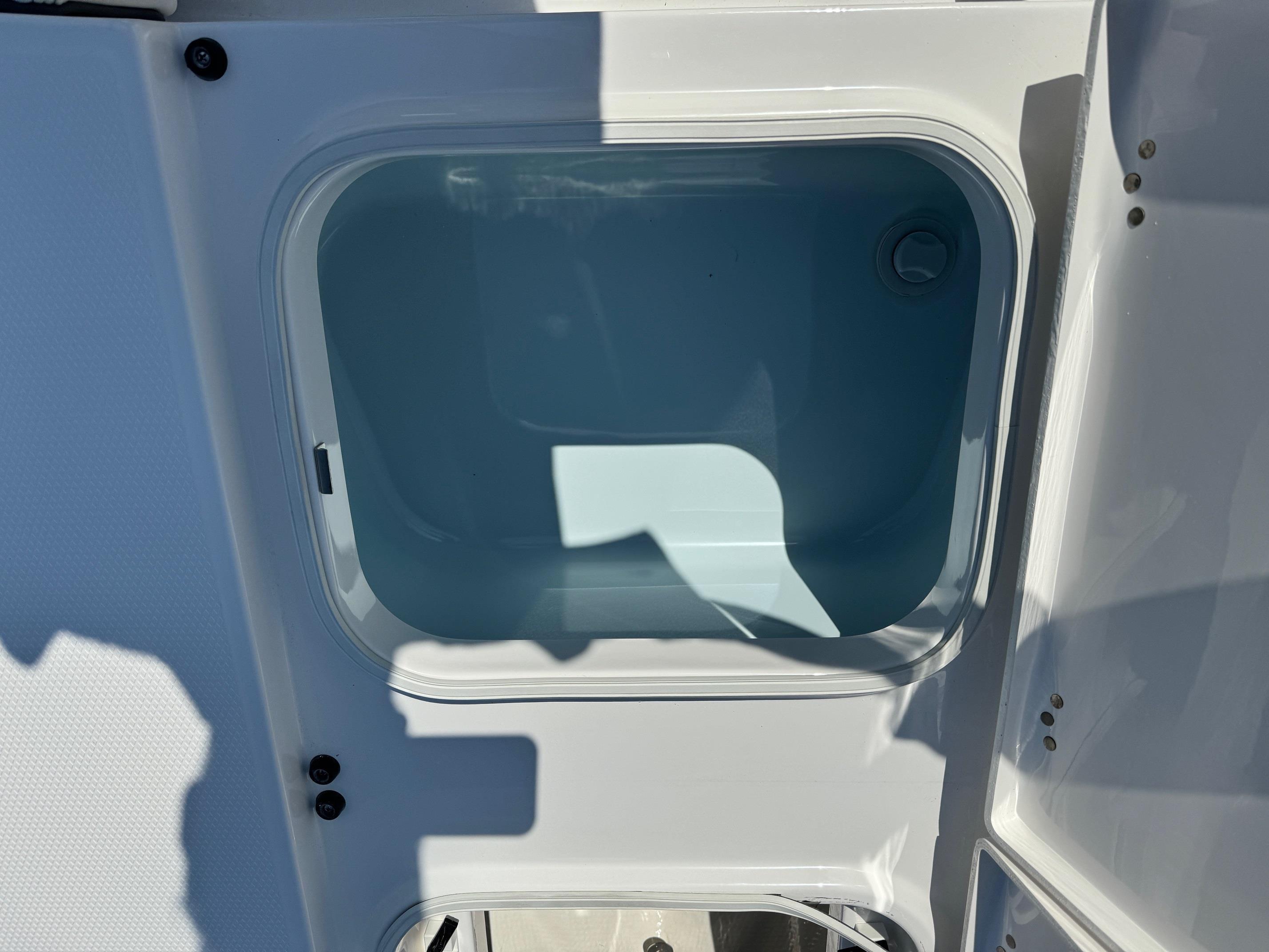 2025 Robalo R246 CAYMAN boat storage compartment, open and empty.