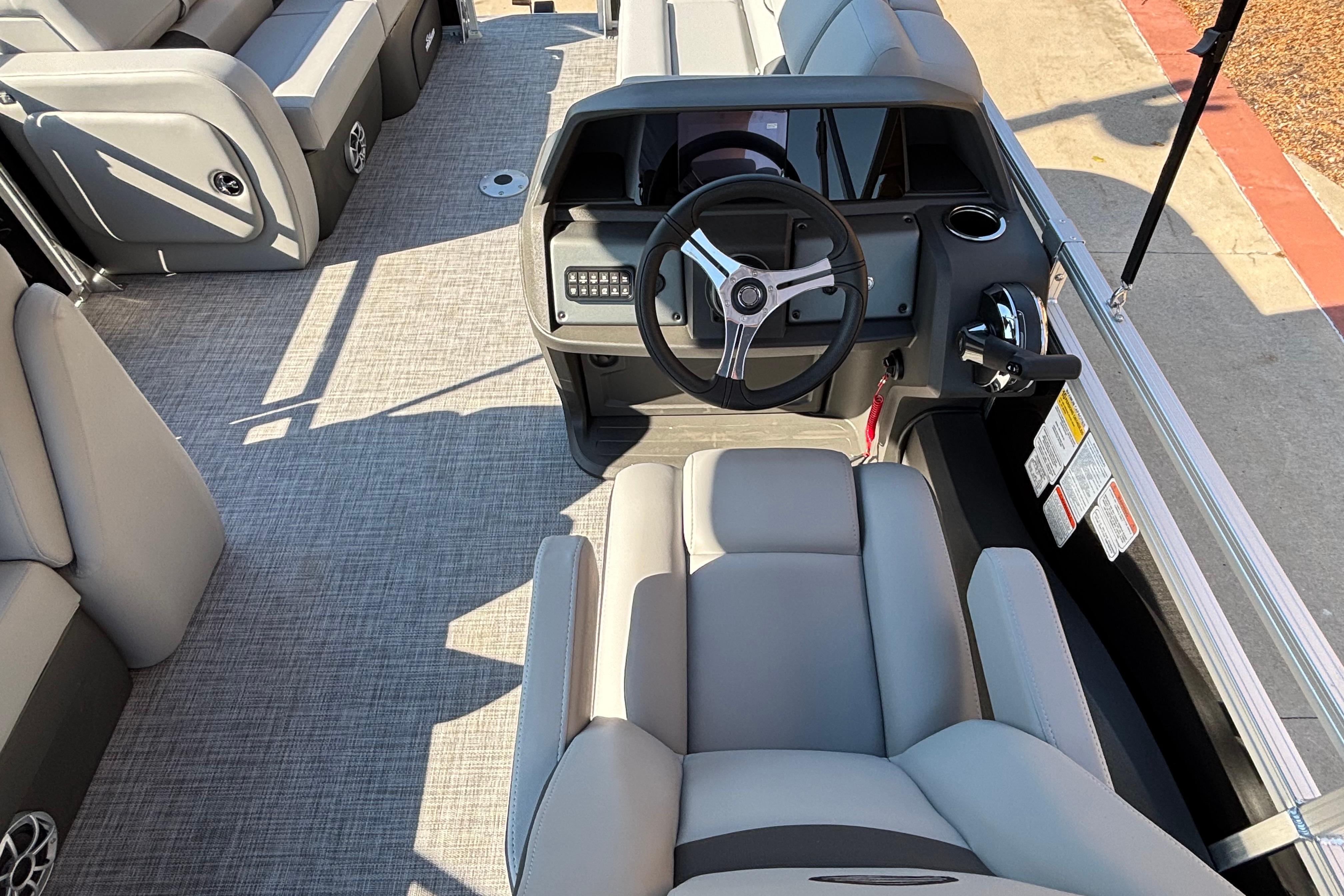 2026 Sun Tracker SportFish 22 DLX boat interior with steering wheel and seating.