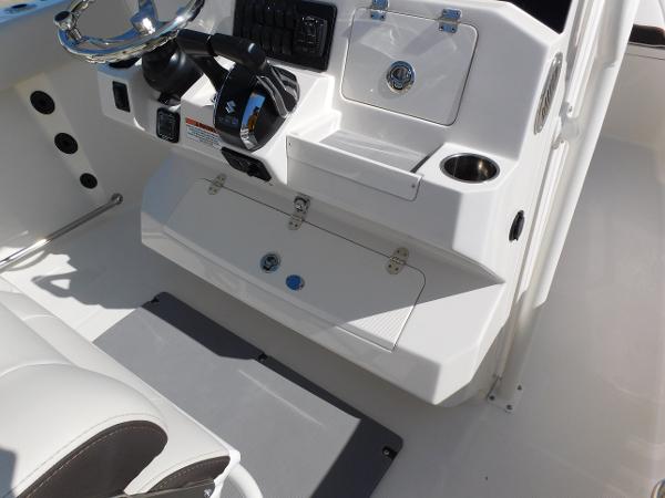 2024 Sailfish 242 CC boat console with steering wheel and storage compartments.