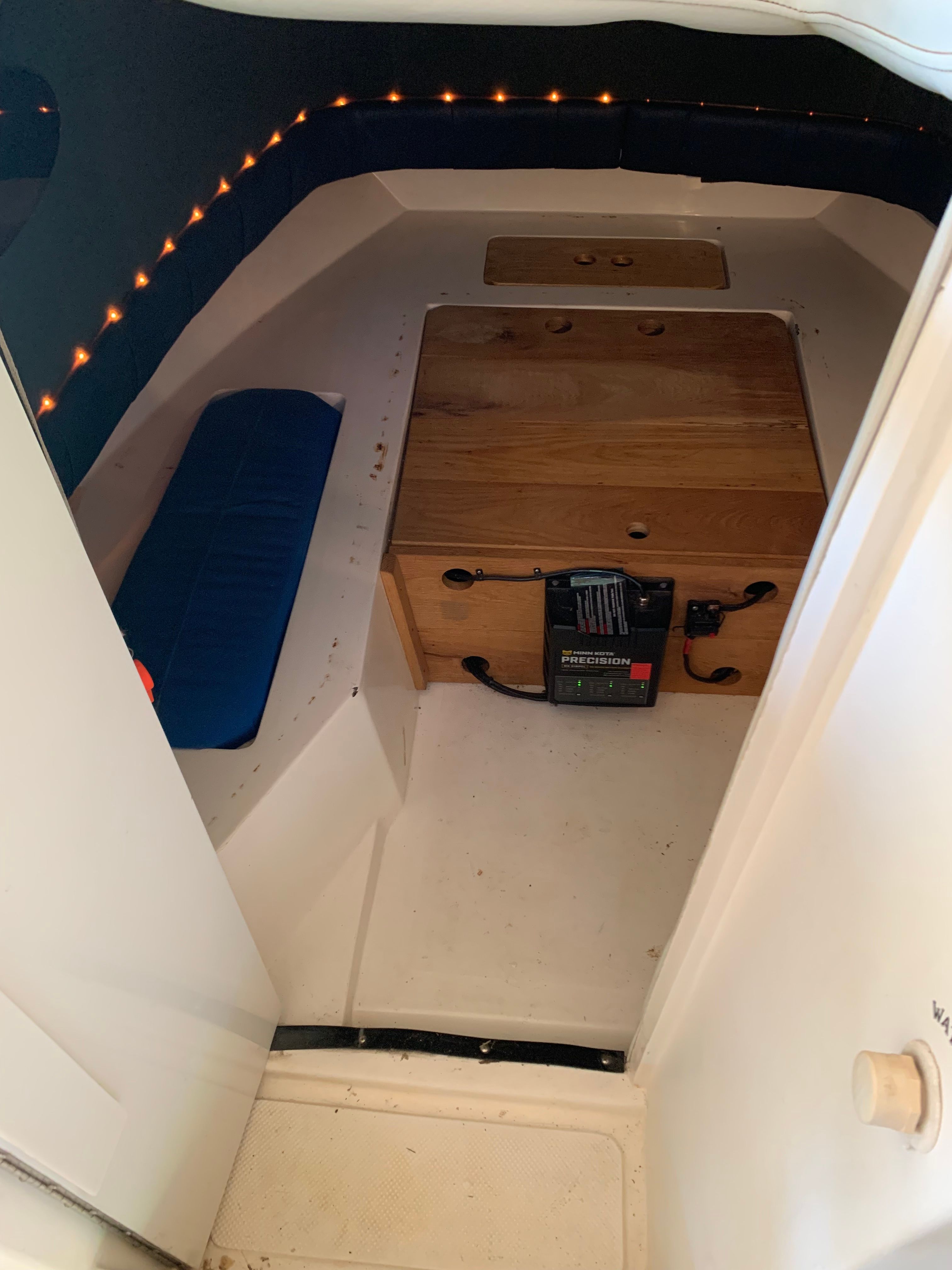 Interior of a 1998 Eurosport 221WA boat with wooden box and blue cushions.