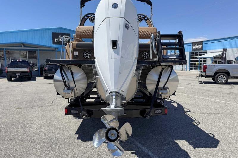 2026 Avalon Excalibur LTD Quad Lounge boat with powerful outboard motor in a dealership lot.