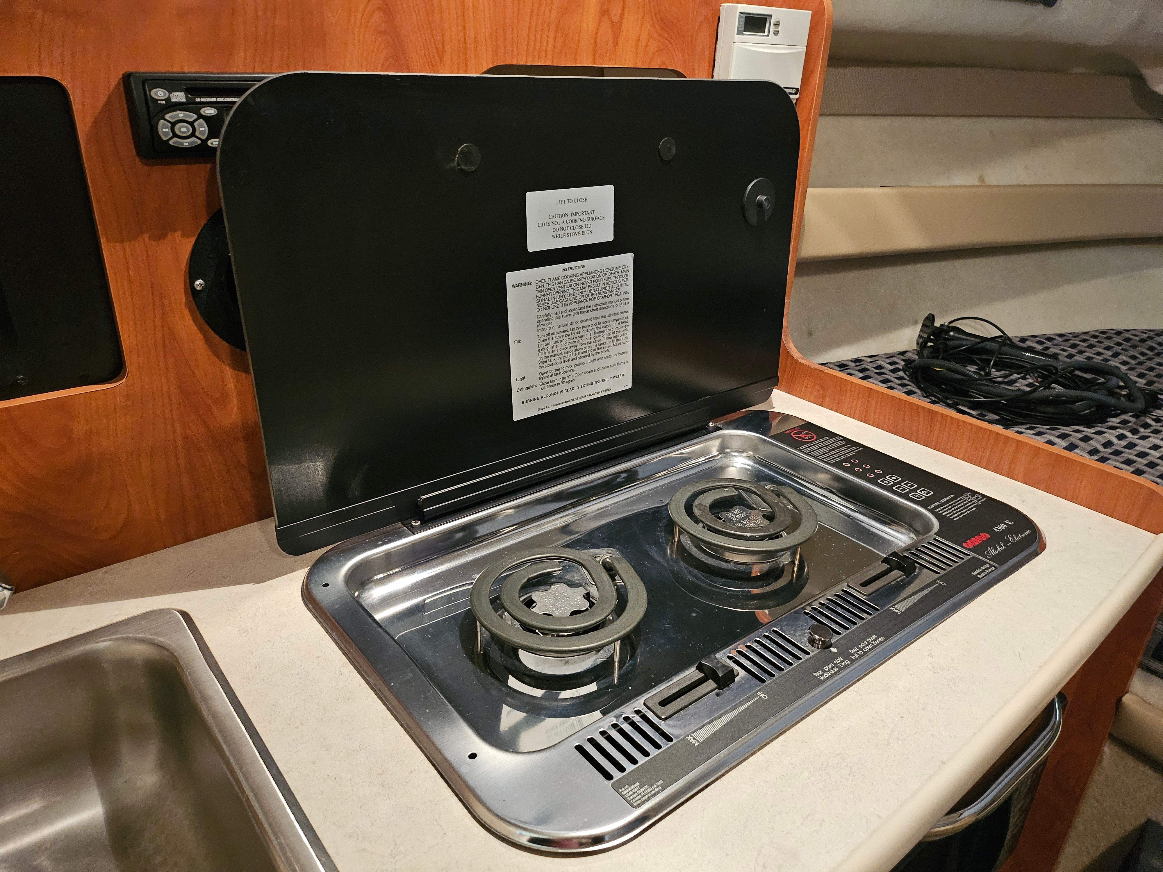 Galley area with a two-burner stove in a 2005 Bayliner 242 Ceara.