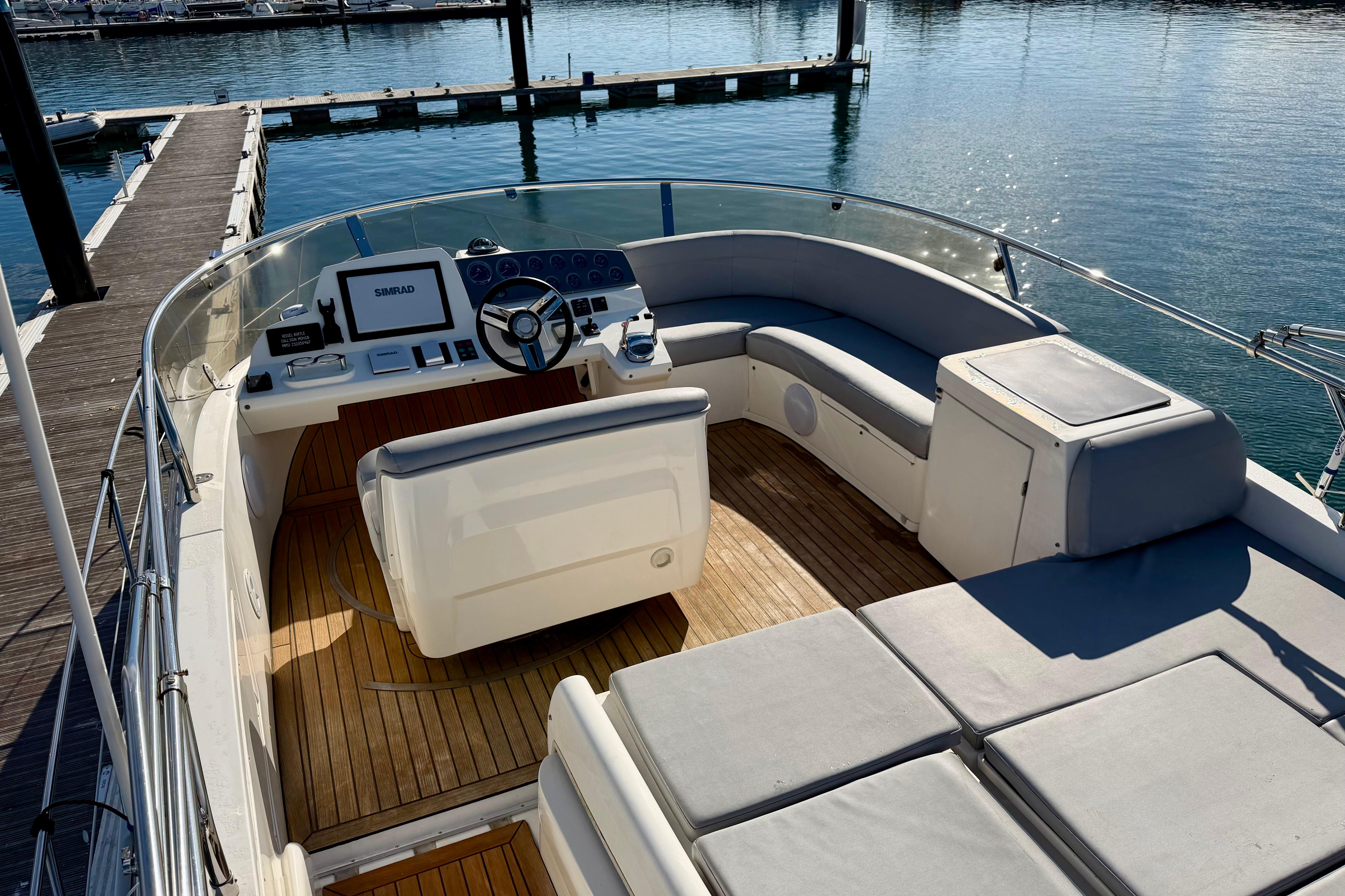 2009 Sealine F42/5 yacht helm with seating, docked at marina.