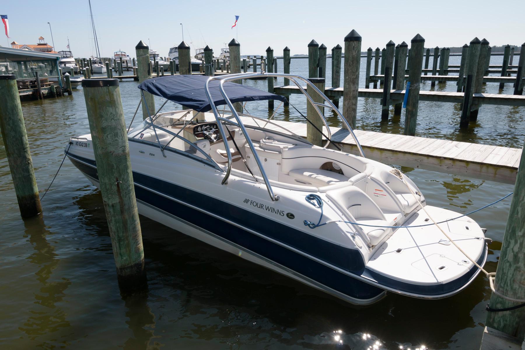 2009 Four Winns 274 Funship boat docked at a marina.