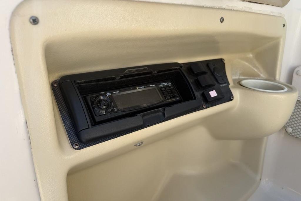 1999 Glastron GT 225 boat dashboard with stereo system and cup holder.