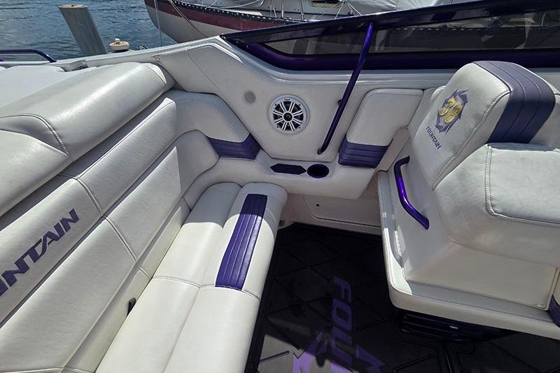 2004 Fountain 38 Lightning boat interior with white and purple seating, speaker, and logo.