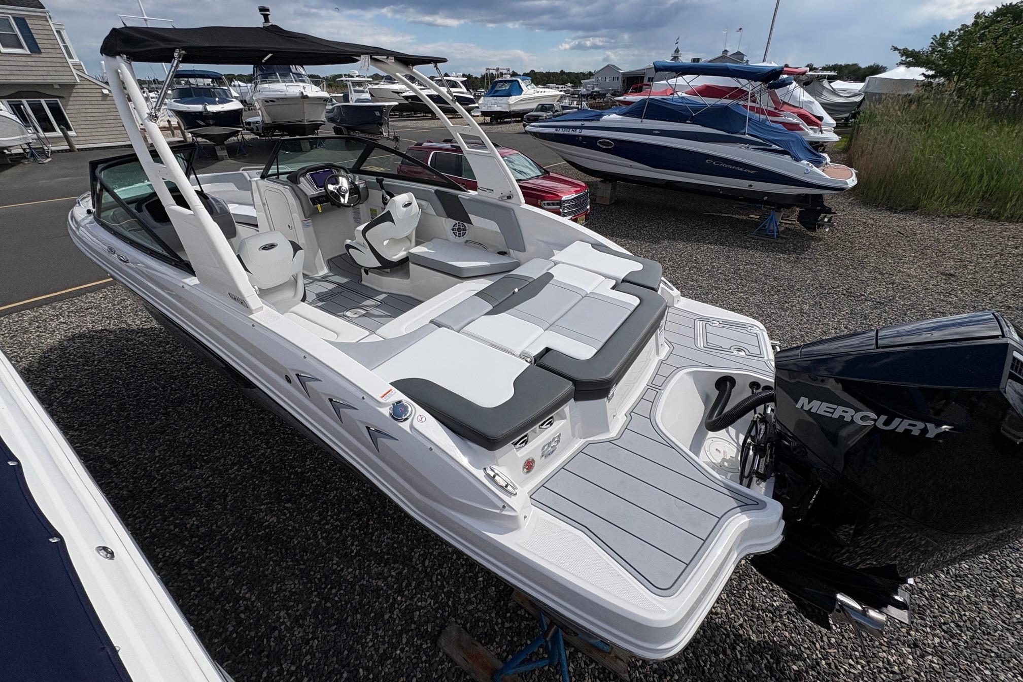 2026 Chaparral 23 SSi OB boat with Mercury outboard engine, docked in a marina.