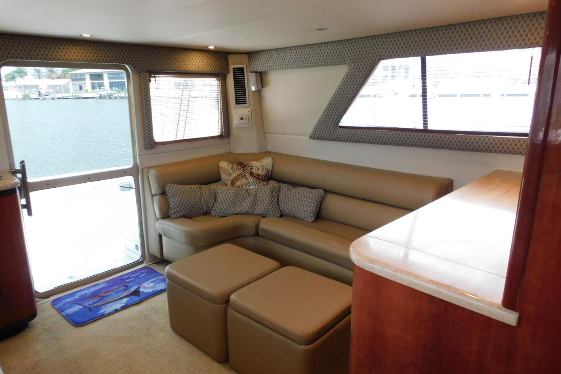 Interior of 1987 Sea Ray 460 Convertible yacht with beige seating and waterfront view.