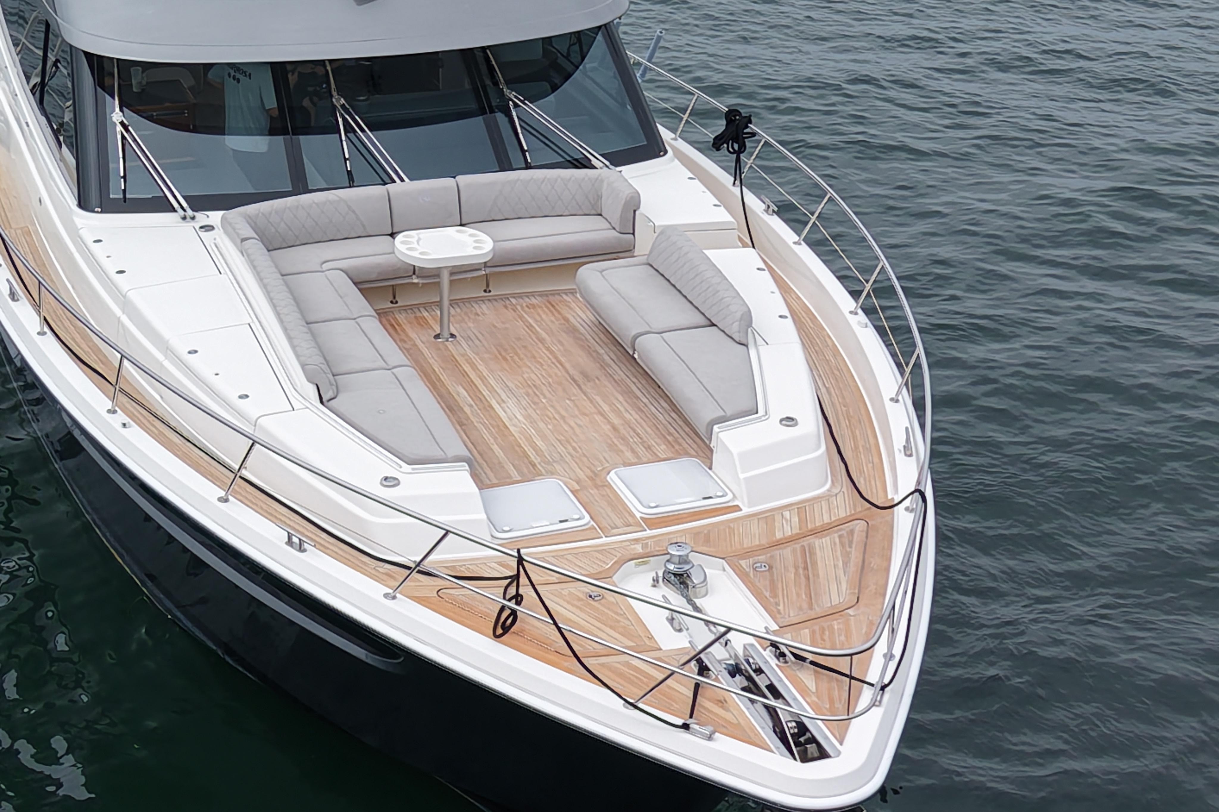 2023 Riviera 645 SUV yacht with spacious deck and luxurious seating on calm water.