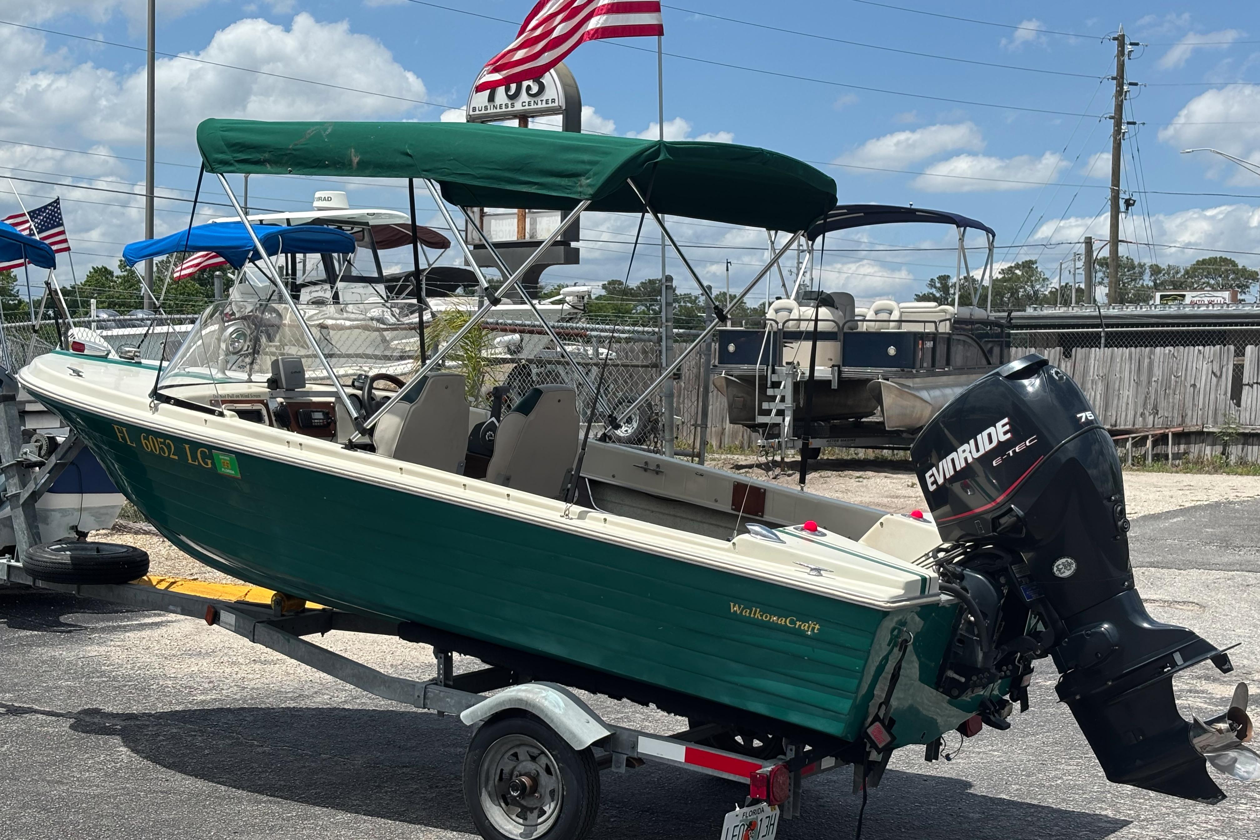 1966 Mohawk 15 boat with Evinrude motor on trailer, parked outdoors under blue sky.