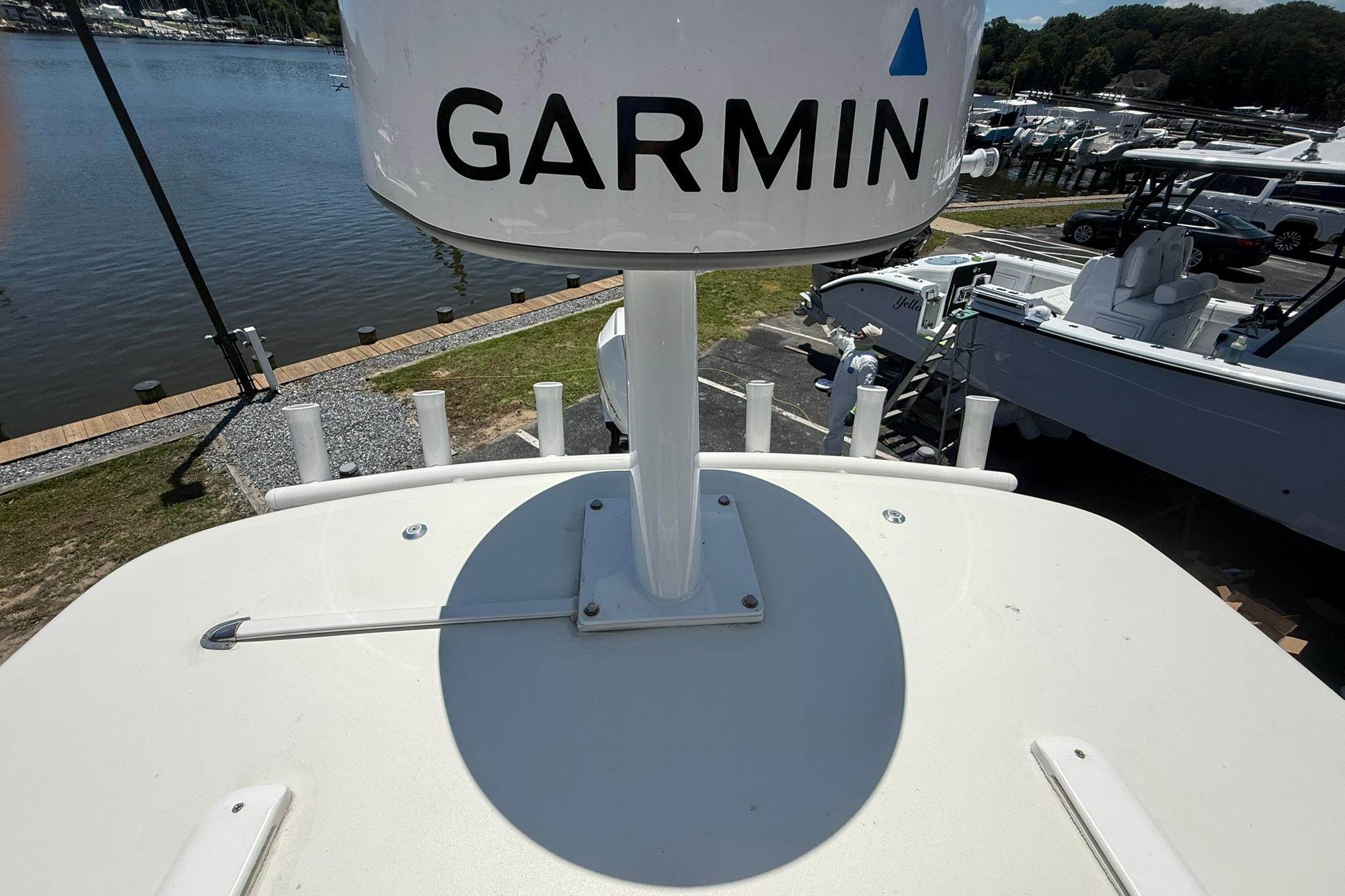 2024 Pair Customs 24 Center Console MV with Garmin radar, docked near a scenic waterfront.