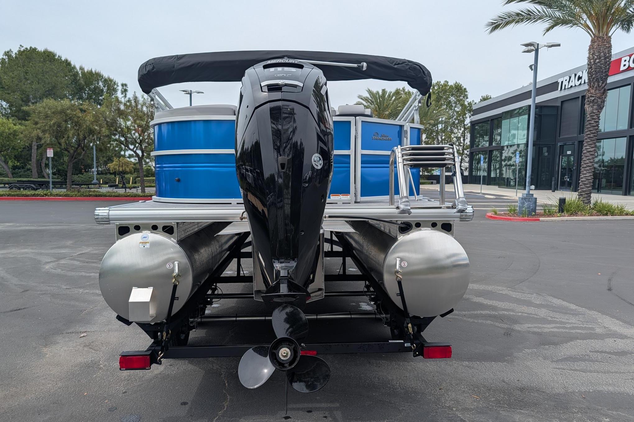 2026 Sun Tracker Party Barge 20 DLX pontoon boat with outboard motor, parked outdoors.