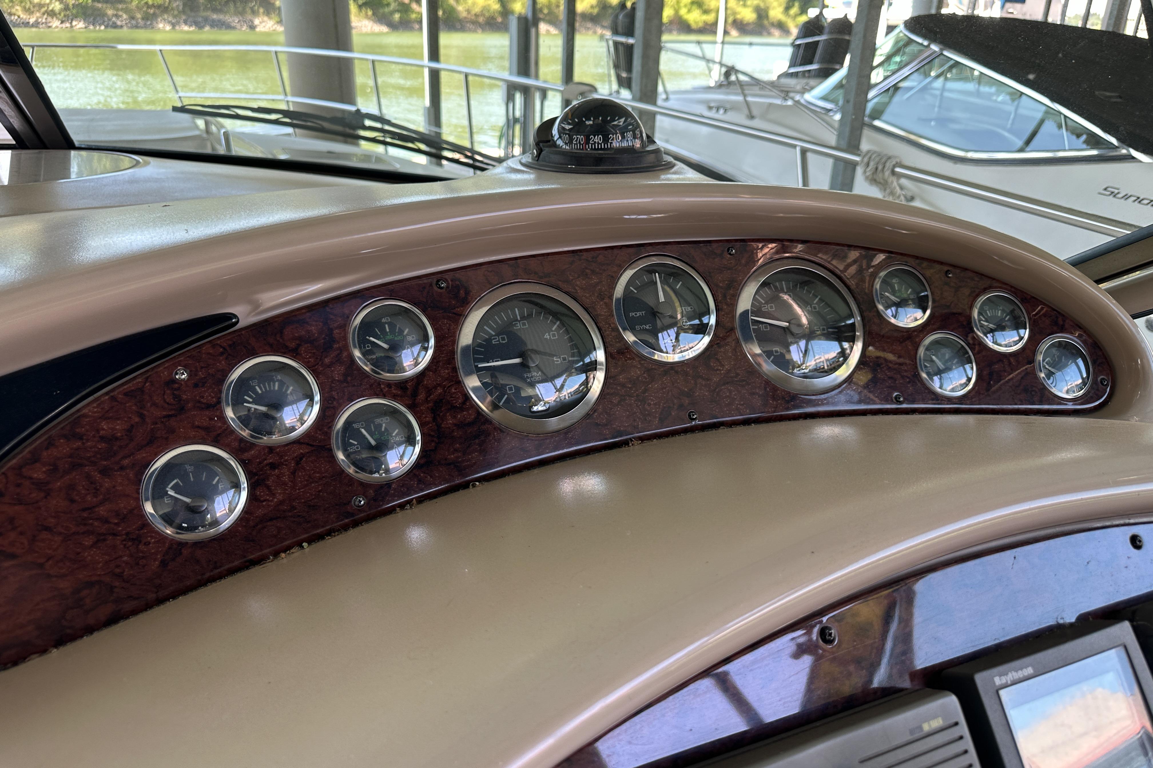 Dashboard of a 2001 Sea Ray 410 Sundancer boat with multiple gauges and compass.
