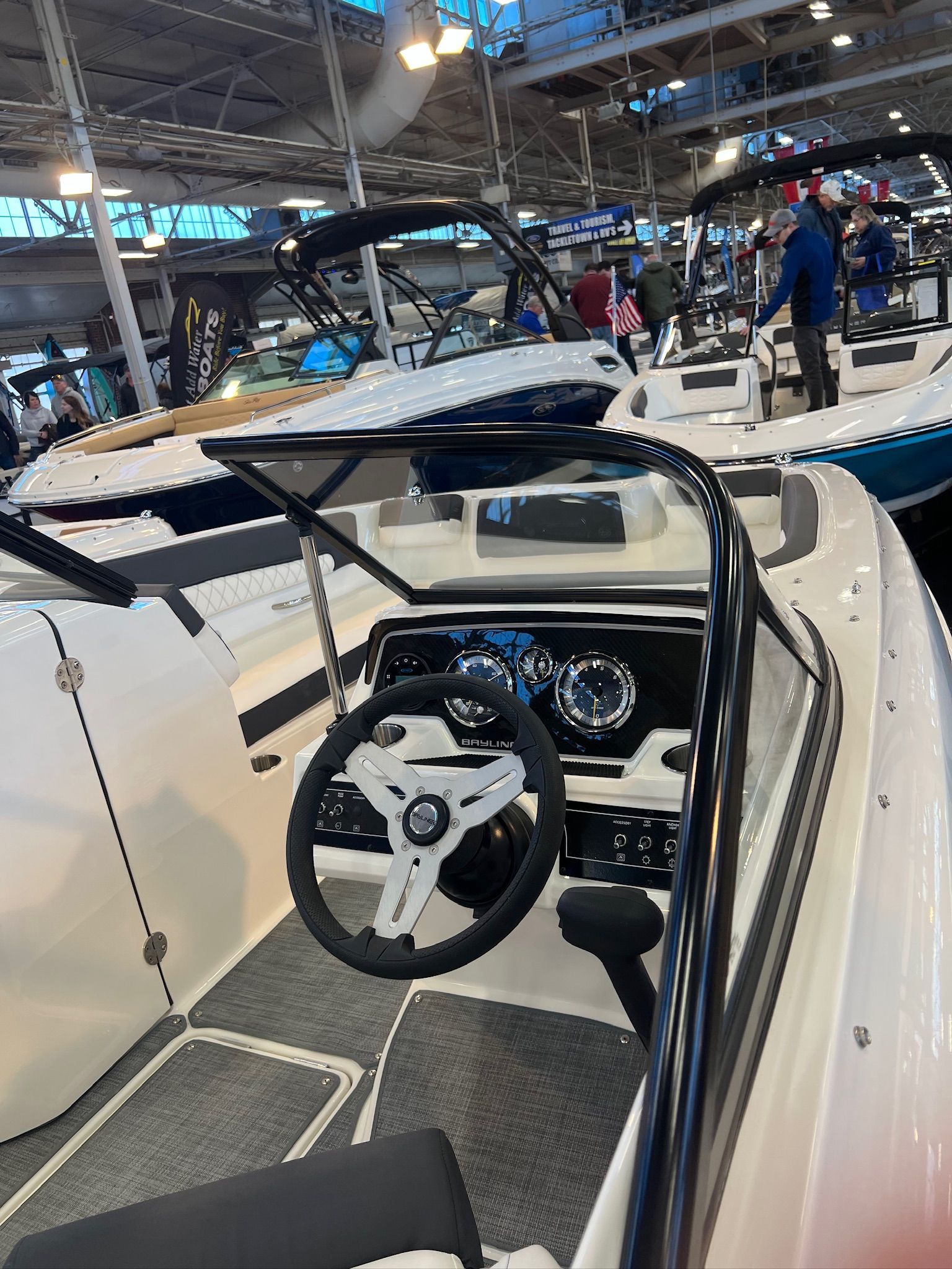 2022 Bayliner DX 2250 boat interior at a boat show, featuring steering wheel and dashboard.