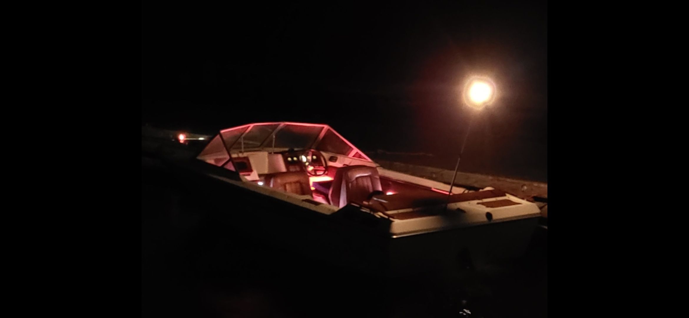 1977 Bayliner Jamaica boat at night with interior lighting.