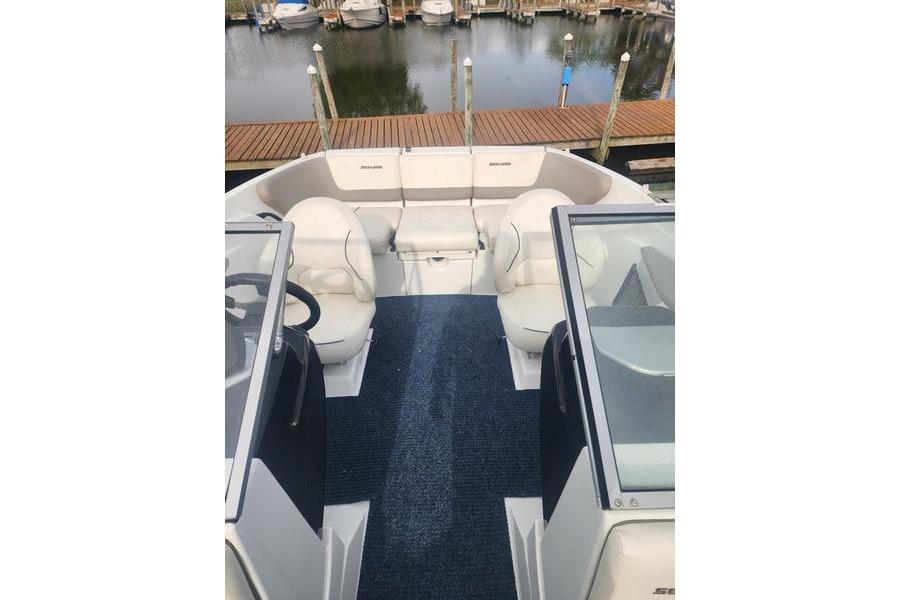 2012 Sea-Doo Sport Boats 180 Challenger interior with seating and steering, docked by the water.