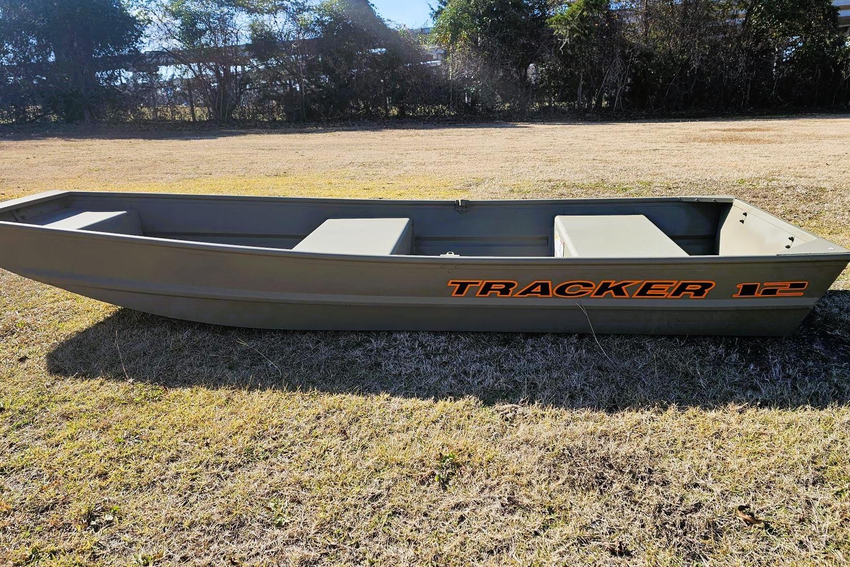2026 Tracker Grizzly 12 Jon boat on grassy field, showcasing durable design and spacious interior.