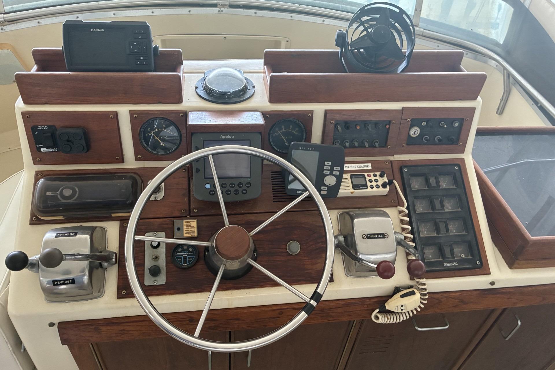 1980 Chris-Craft 360 Commander helm with steering wheel, gauges, and navigation equipment.