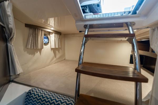 Interior cabin of 2016 Regal 28 Express boat with wooden ladder and porthole window.