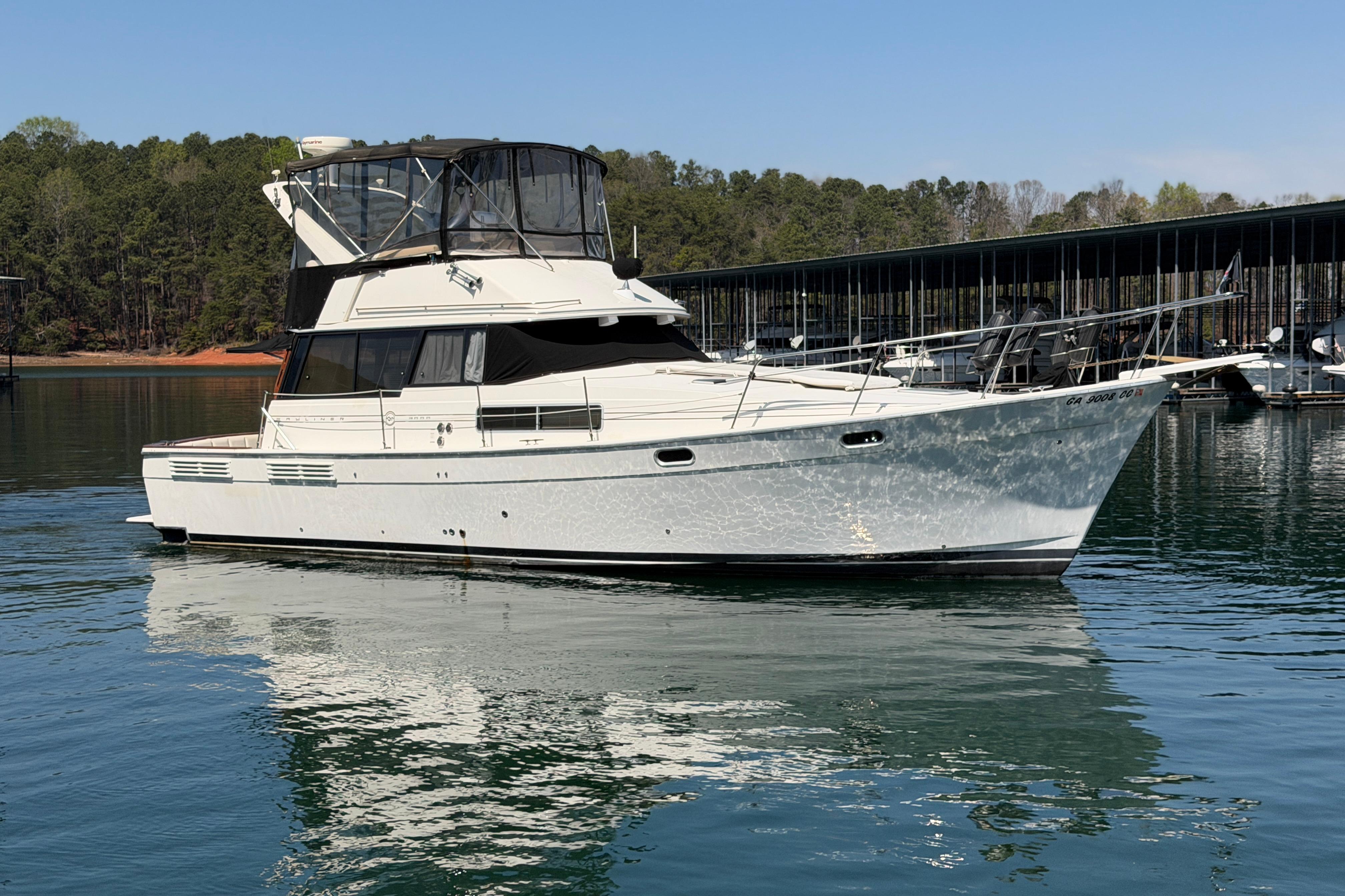 1994 Bayliner 3888 MY Sedan yacht on calm water near a marina.