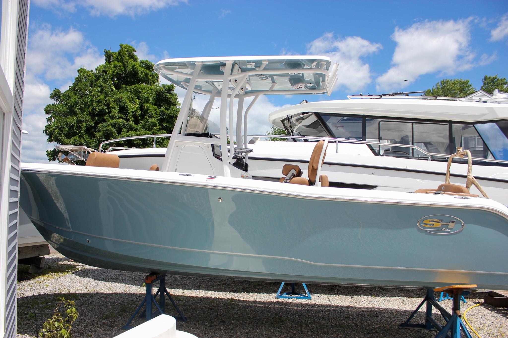 2027 Sea Hunt Ultra 234 boat on stands, displayed outdoors under a clear blue sky.