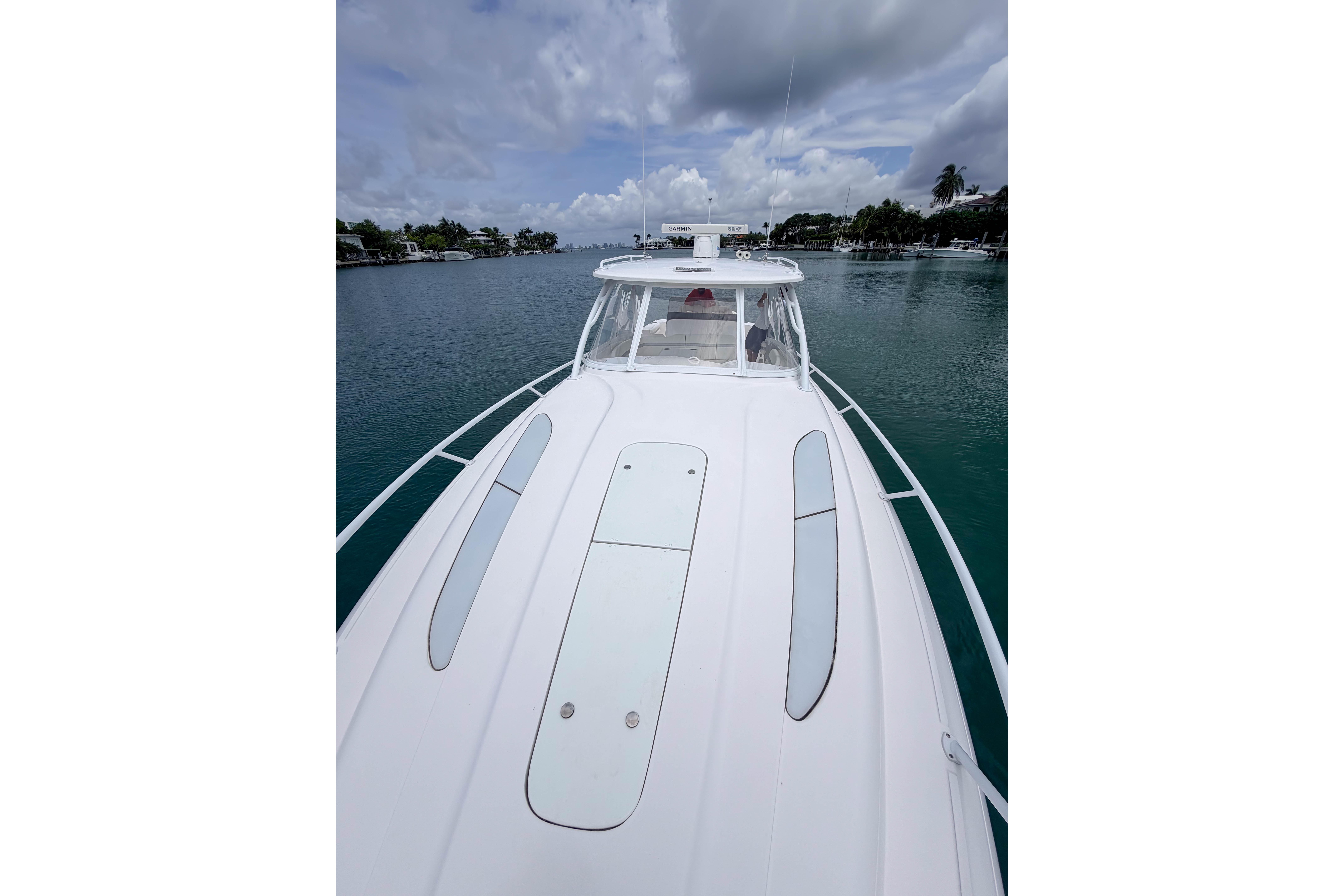 2021 Intrepid 409 Valor boat on calm water under cloudy sky.