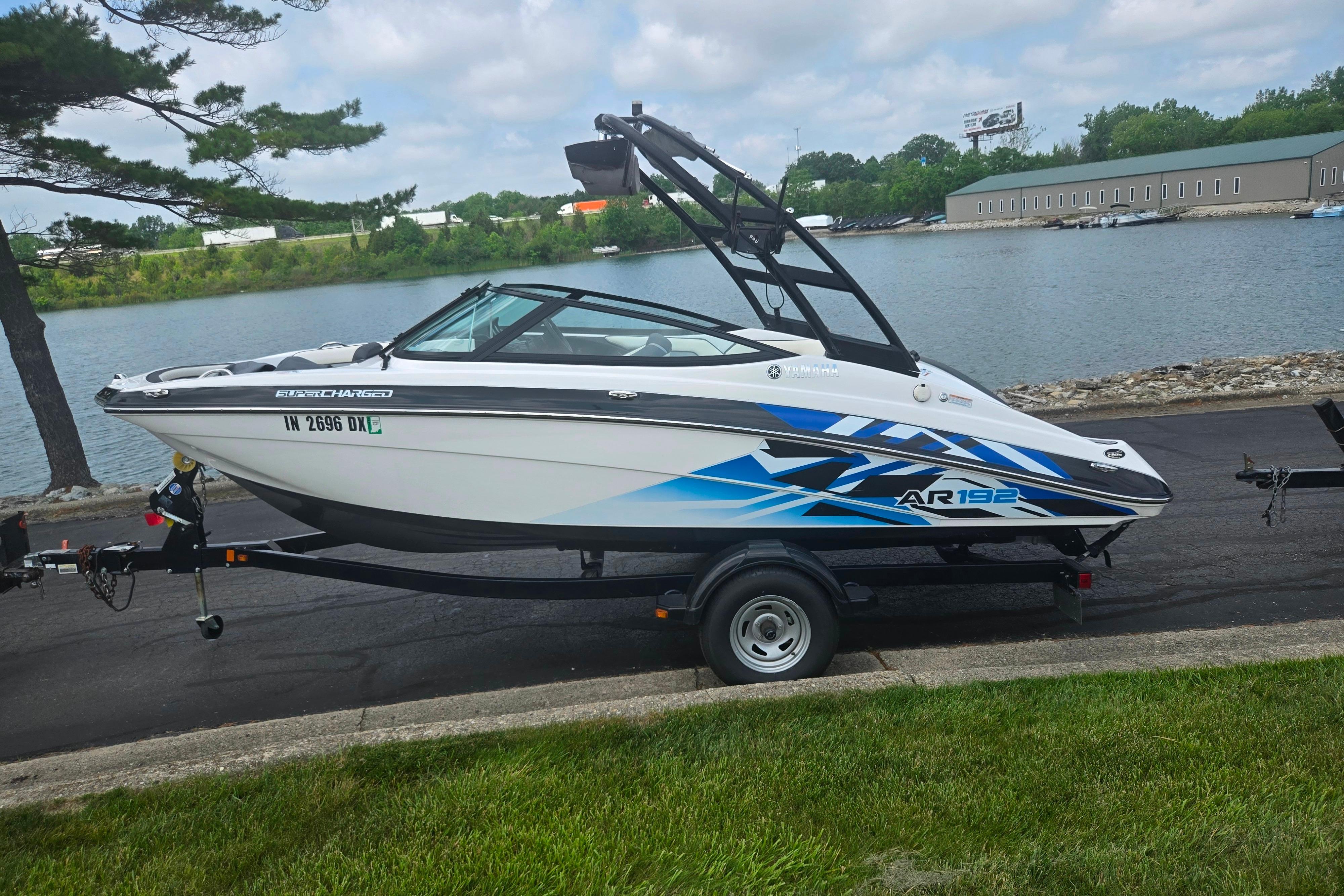 2016 Yamaha AR192 boat on trailer by a lakeside, featuring sleek design and graphics.