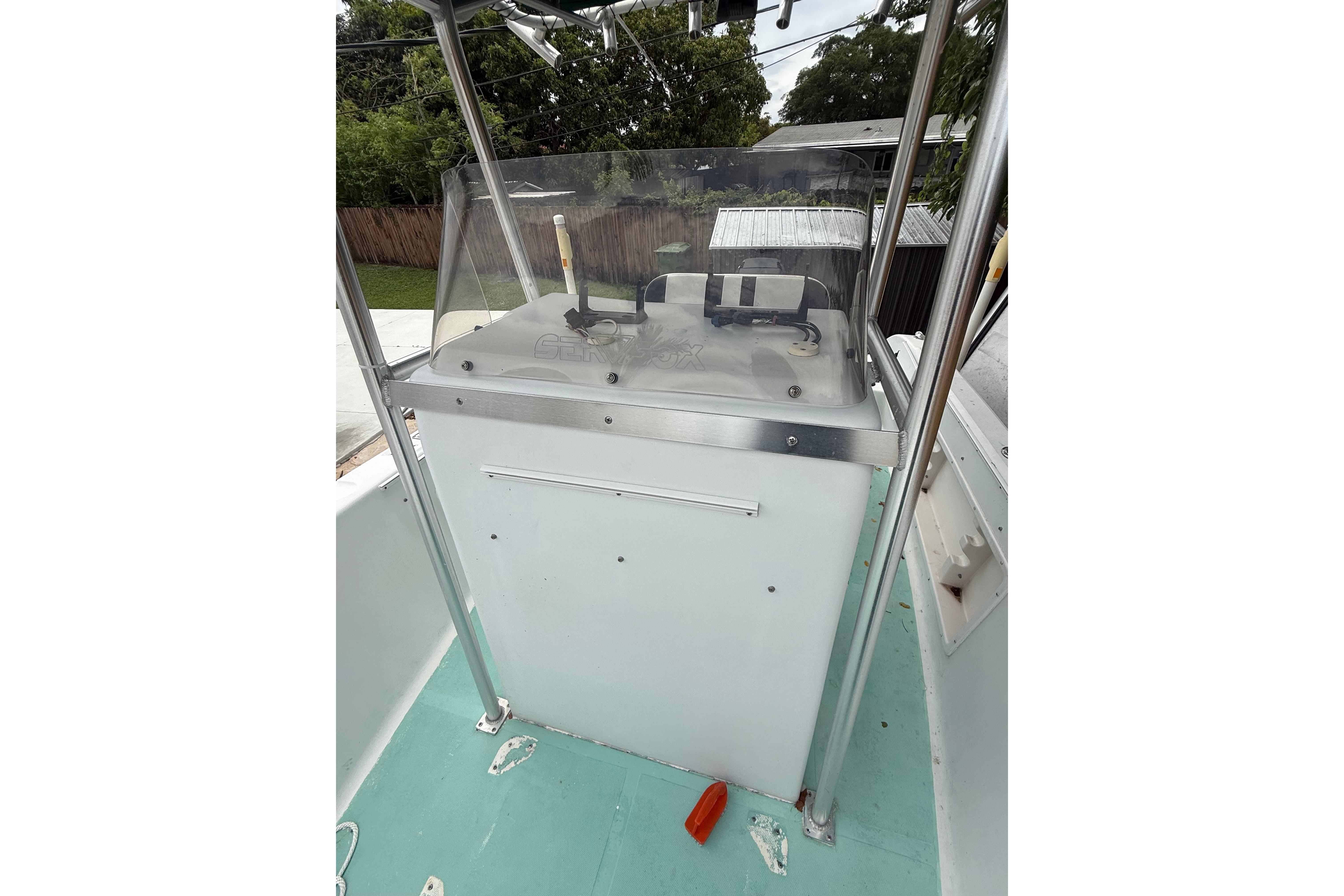 2005 LYG Sea Fox boat console with windshield and controls, set against a backyard backdrop.