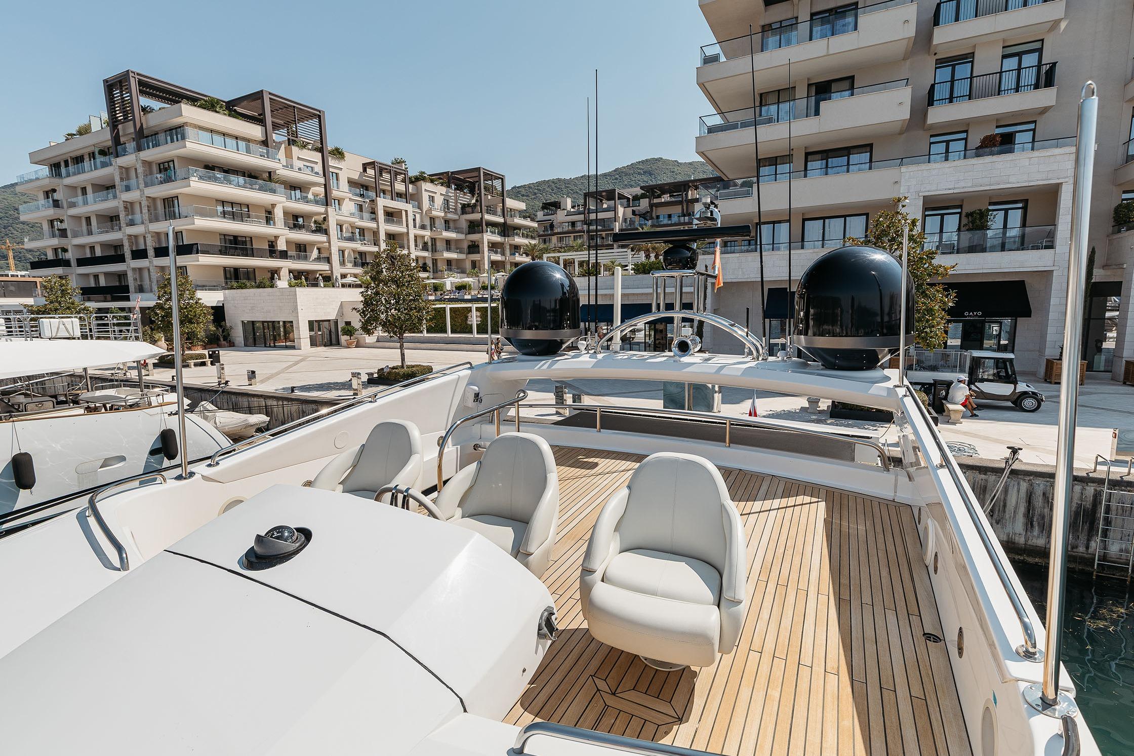 Luxurious 2009 Sunseeker Predator 92 yacht docked near modern waterfront apartments.