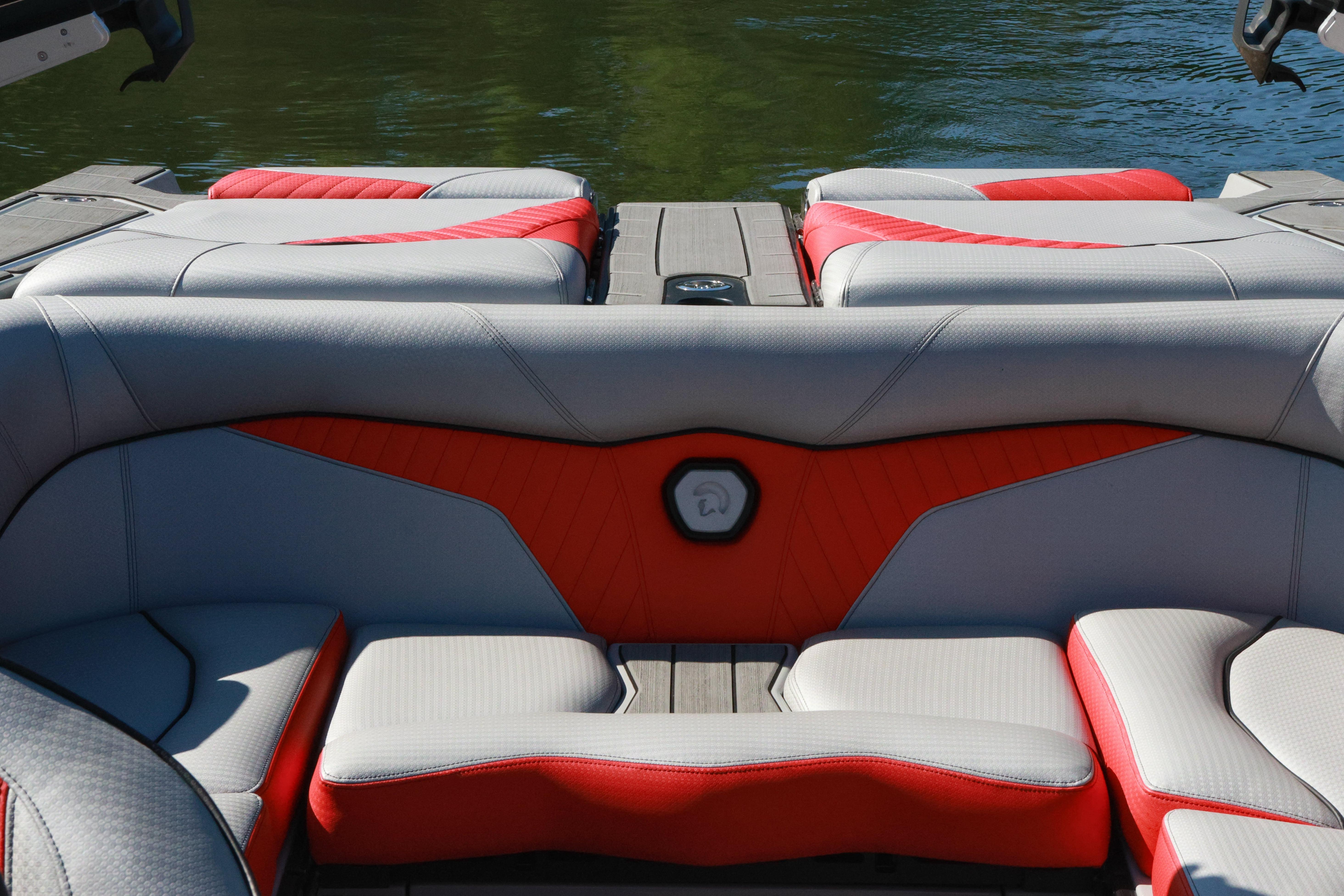 2024 Centurion Fi23 boat interior with red and gray seating, on calm water.