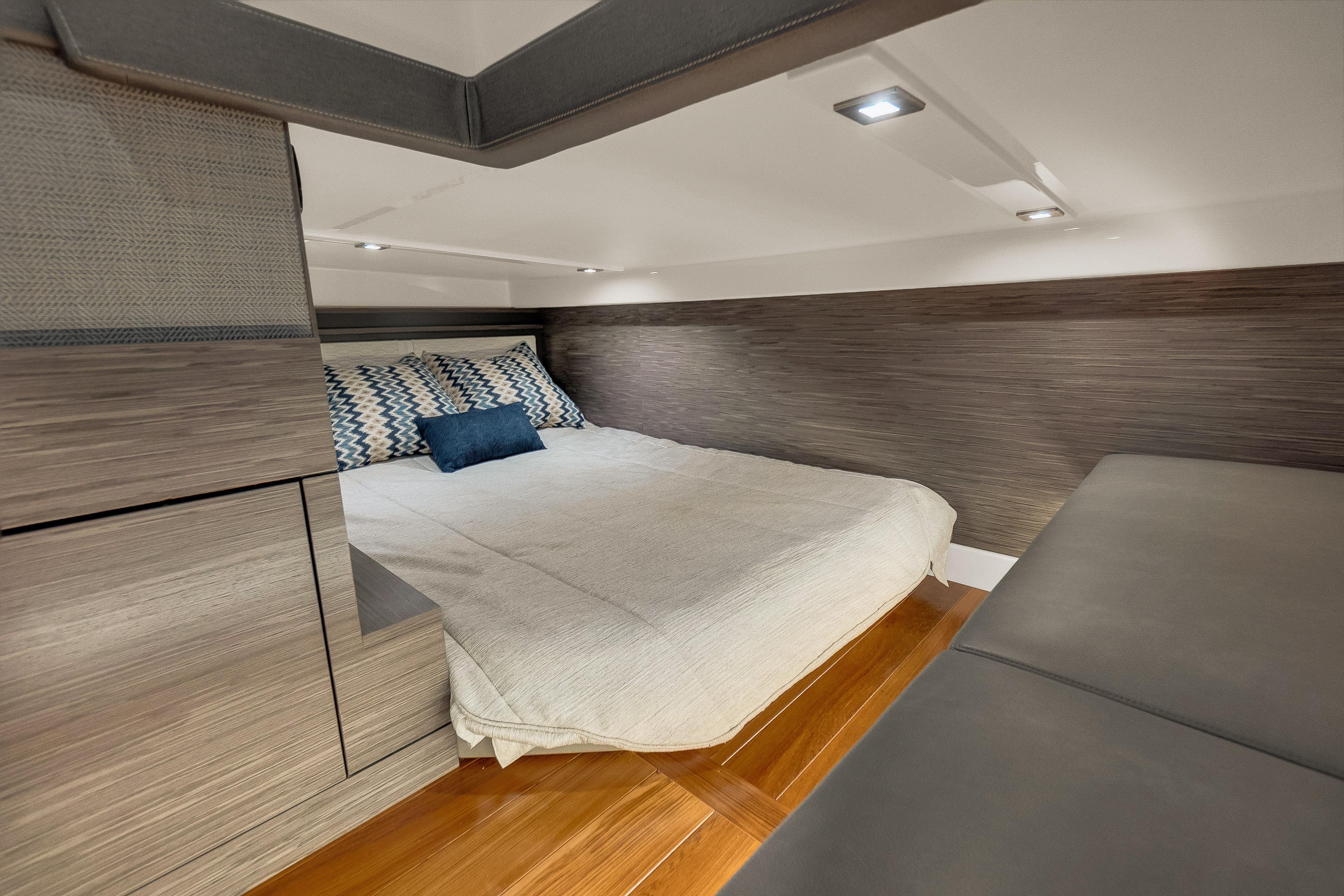 Luxurious cabin interior of 2021 Tiara Sport 43 LE yacht with modern bedding and wood accents.