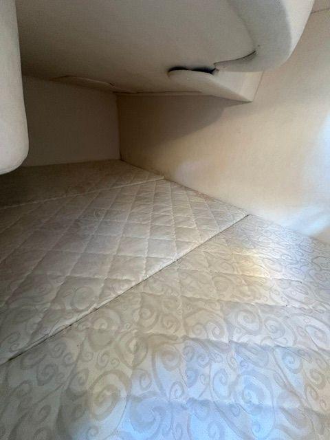 Interior of the 2005 Sea Ray Sundancer 280 with a cushioned sleeping area.