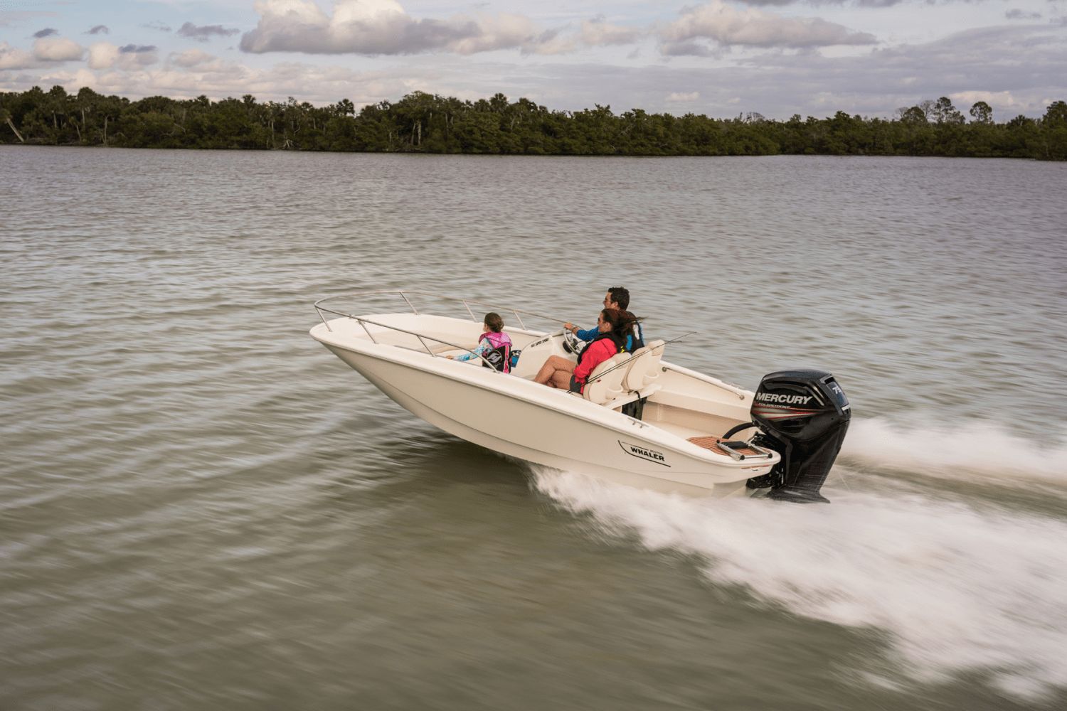 A Boston Whaler 160 Super Sport speeds across the water with three people on board.