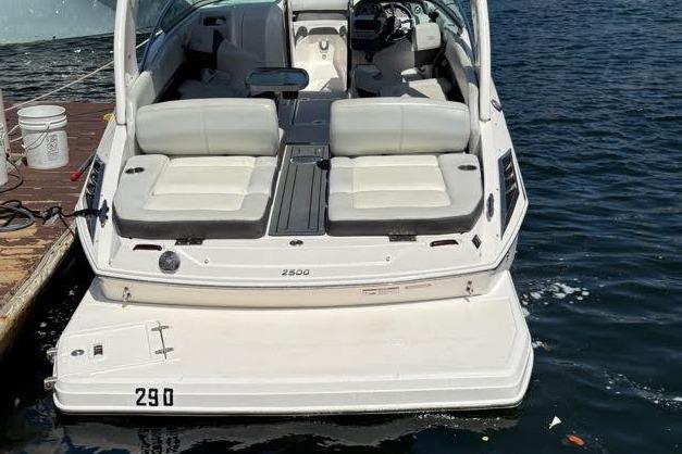 2014 Regal 2500 Bowrider boat docked on water, rear view with seating area.