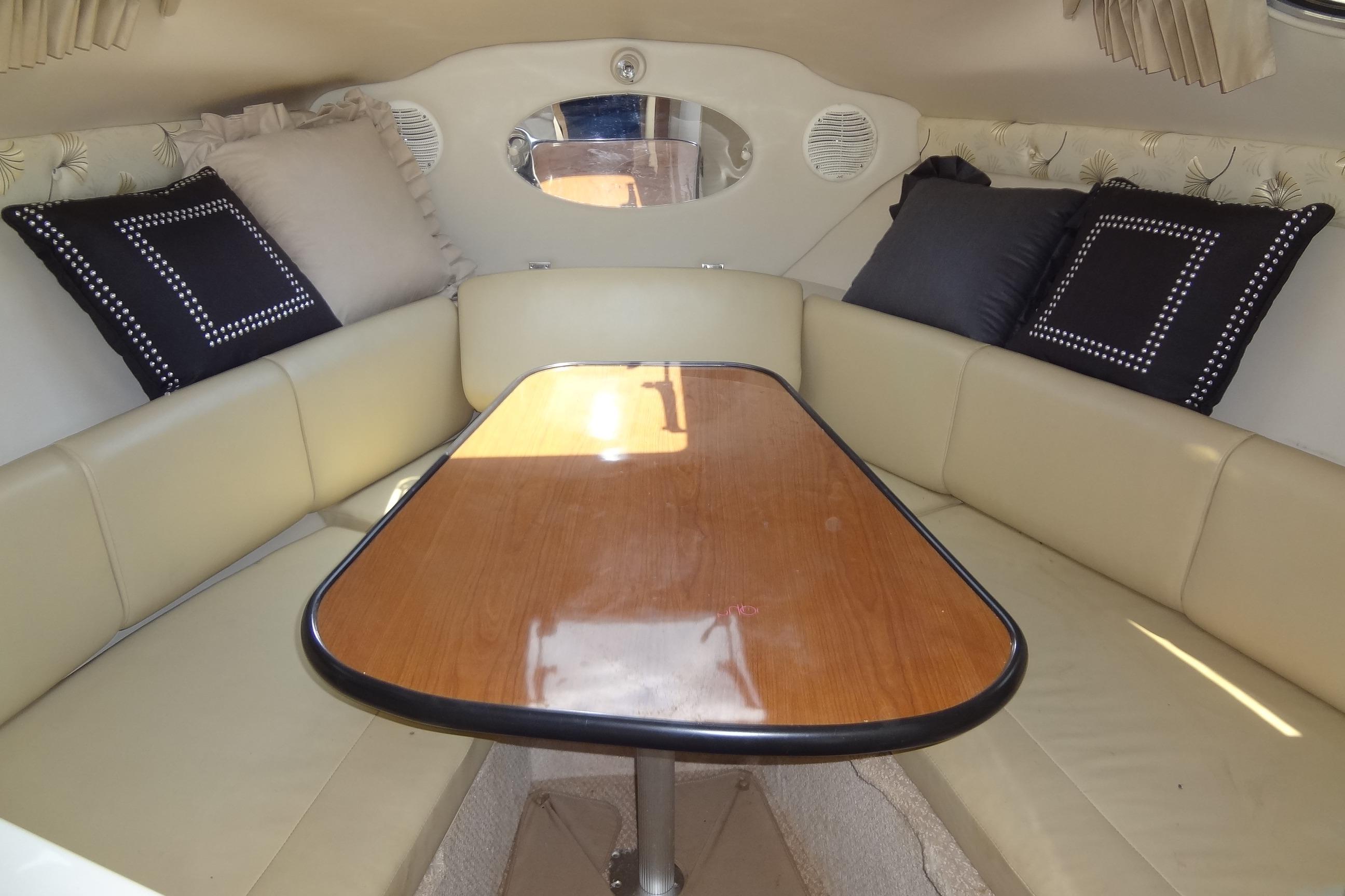Interior of 2000 Chaparral Signature 260 boat with cushioned seating and wooden table.