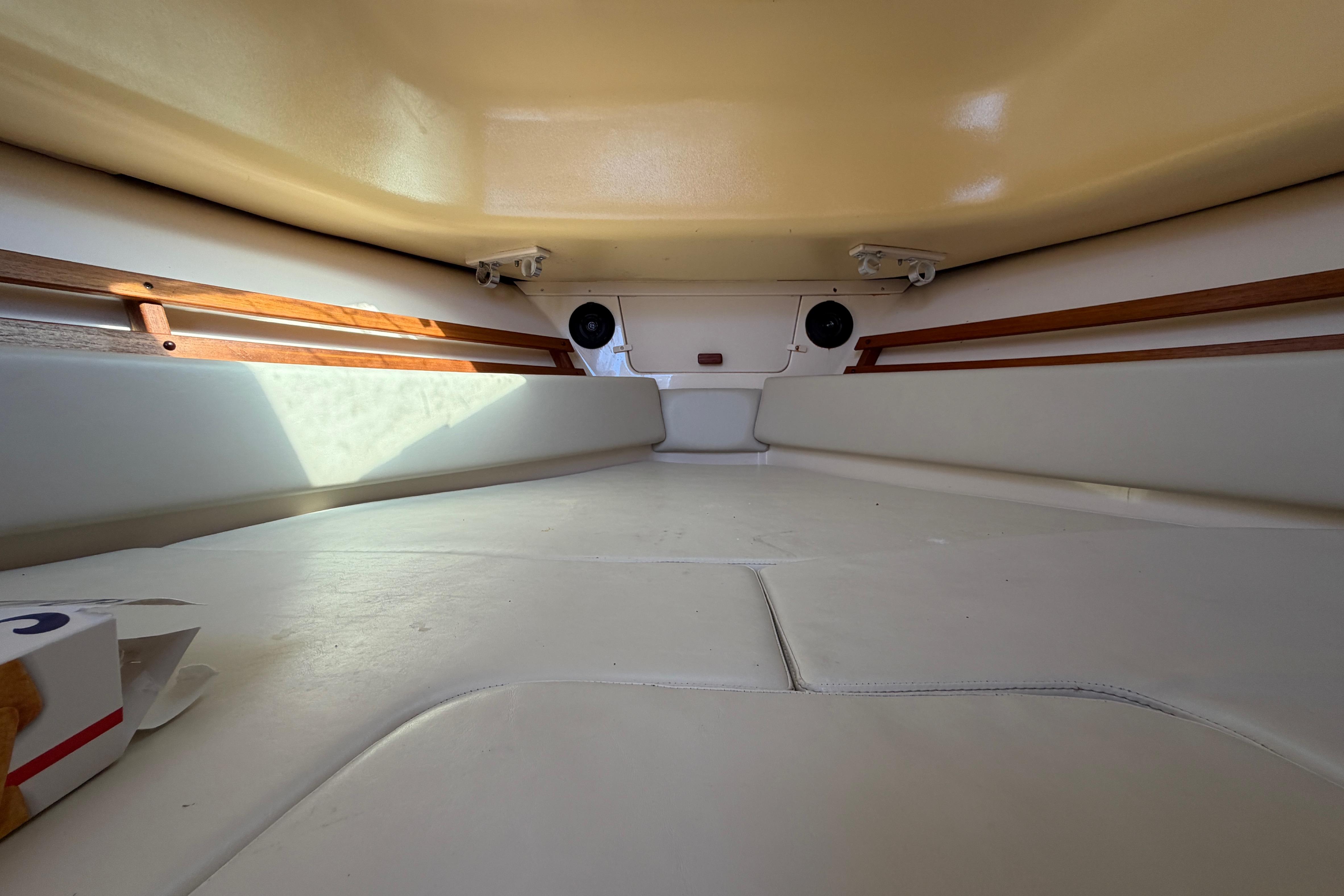 Interior cabin of 2006 Grady-White Sailfish 282 boat, featuring cushioned seating and wooden accents.