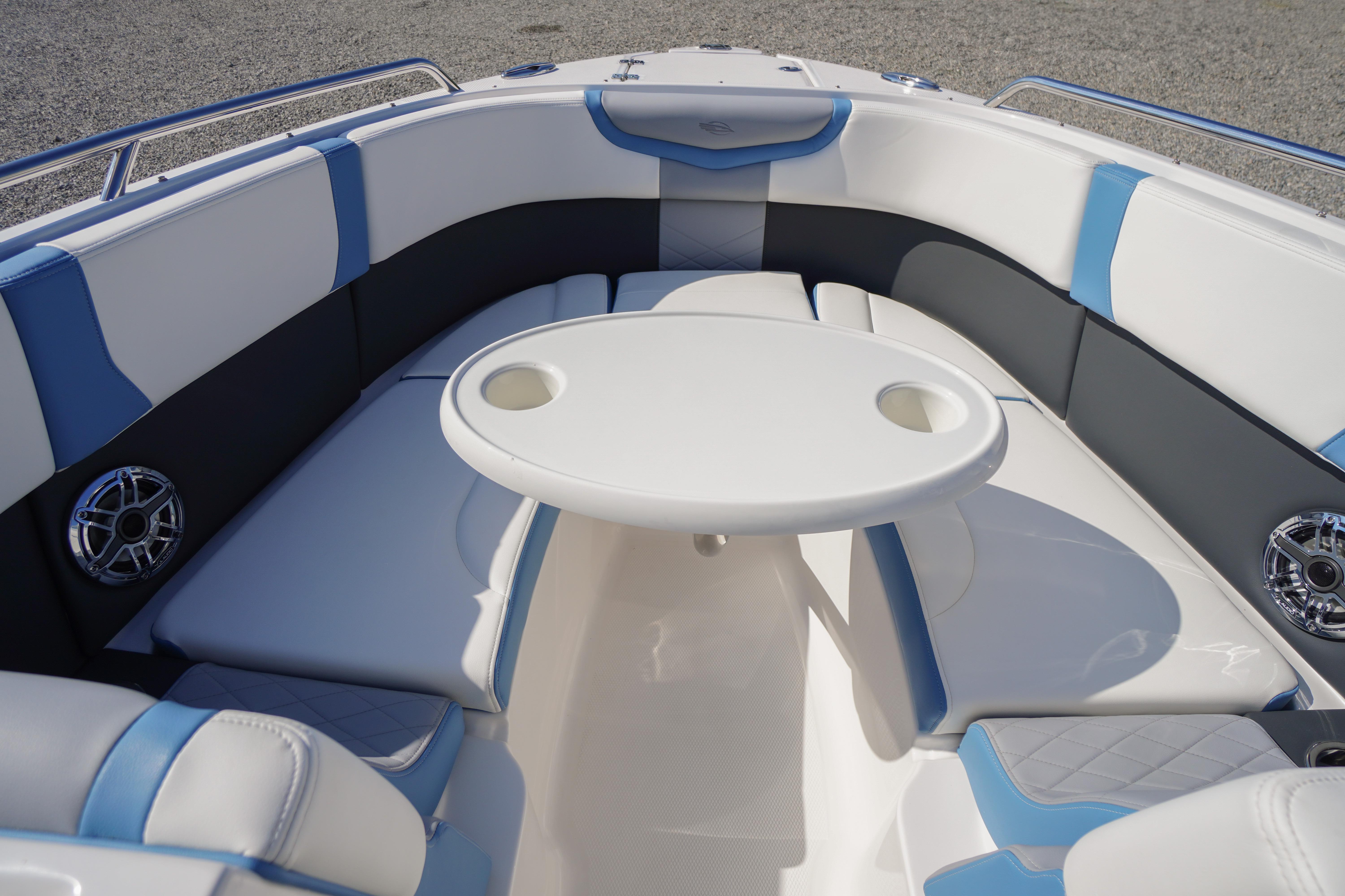 Luxurious seating area on the 2026 Chaparral 270 OSX boat with table and speakers.