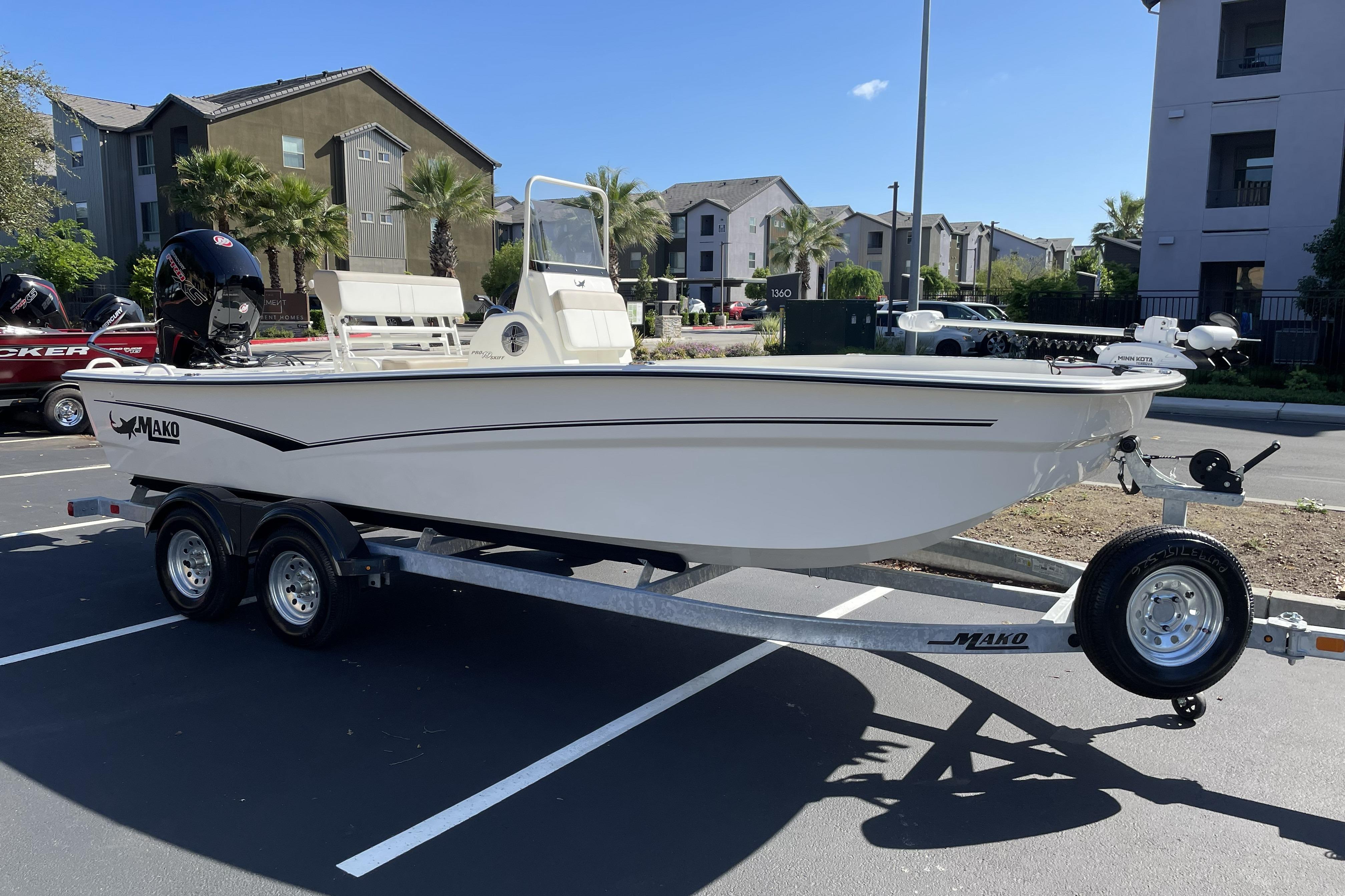 2026 Mako Pro Skiff 19 CC boat on trailer in parking lot, sunny day.