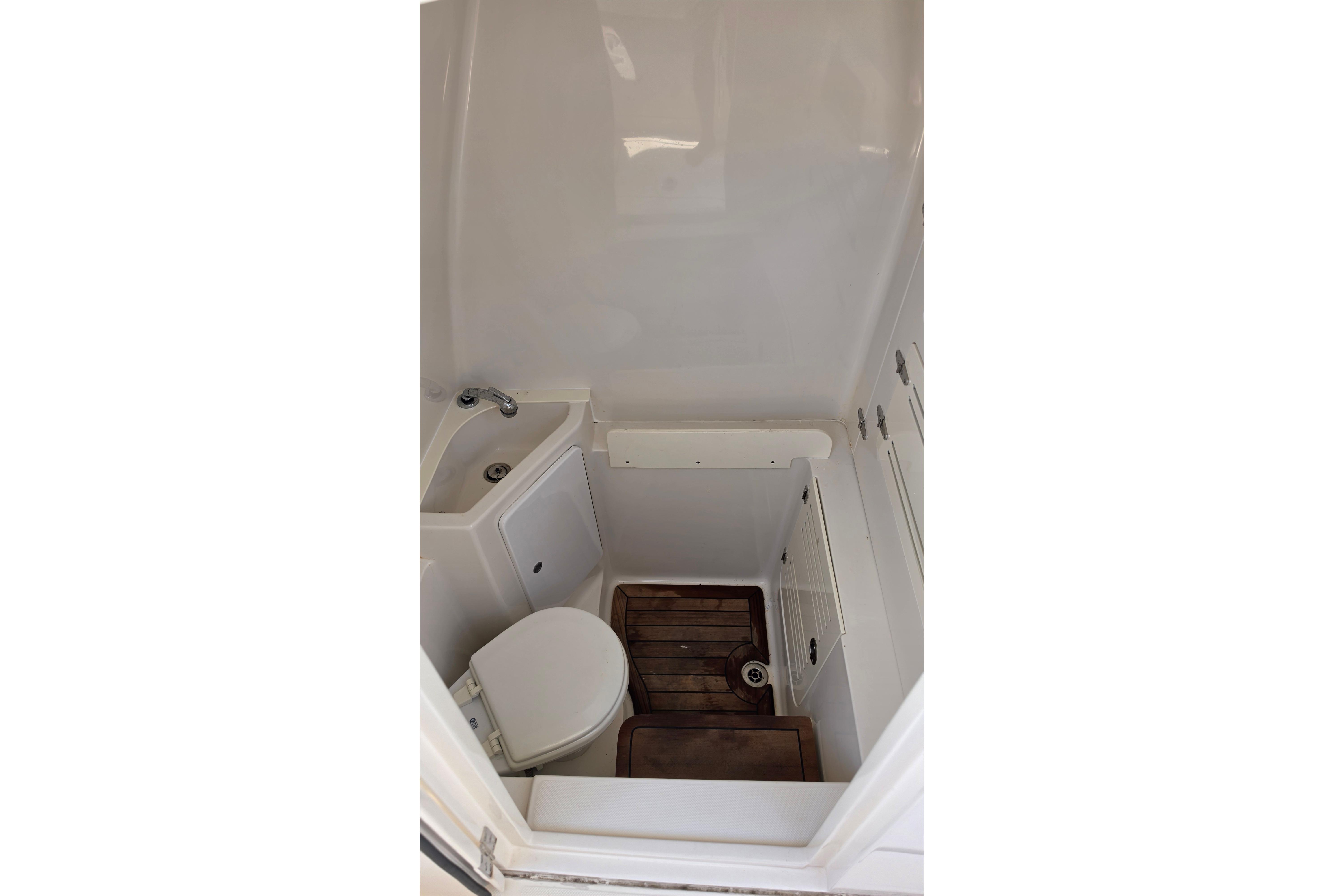 Compact bathroom in 2020 Jupiter 34 HFS boat with toilet and sink.