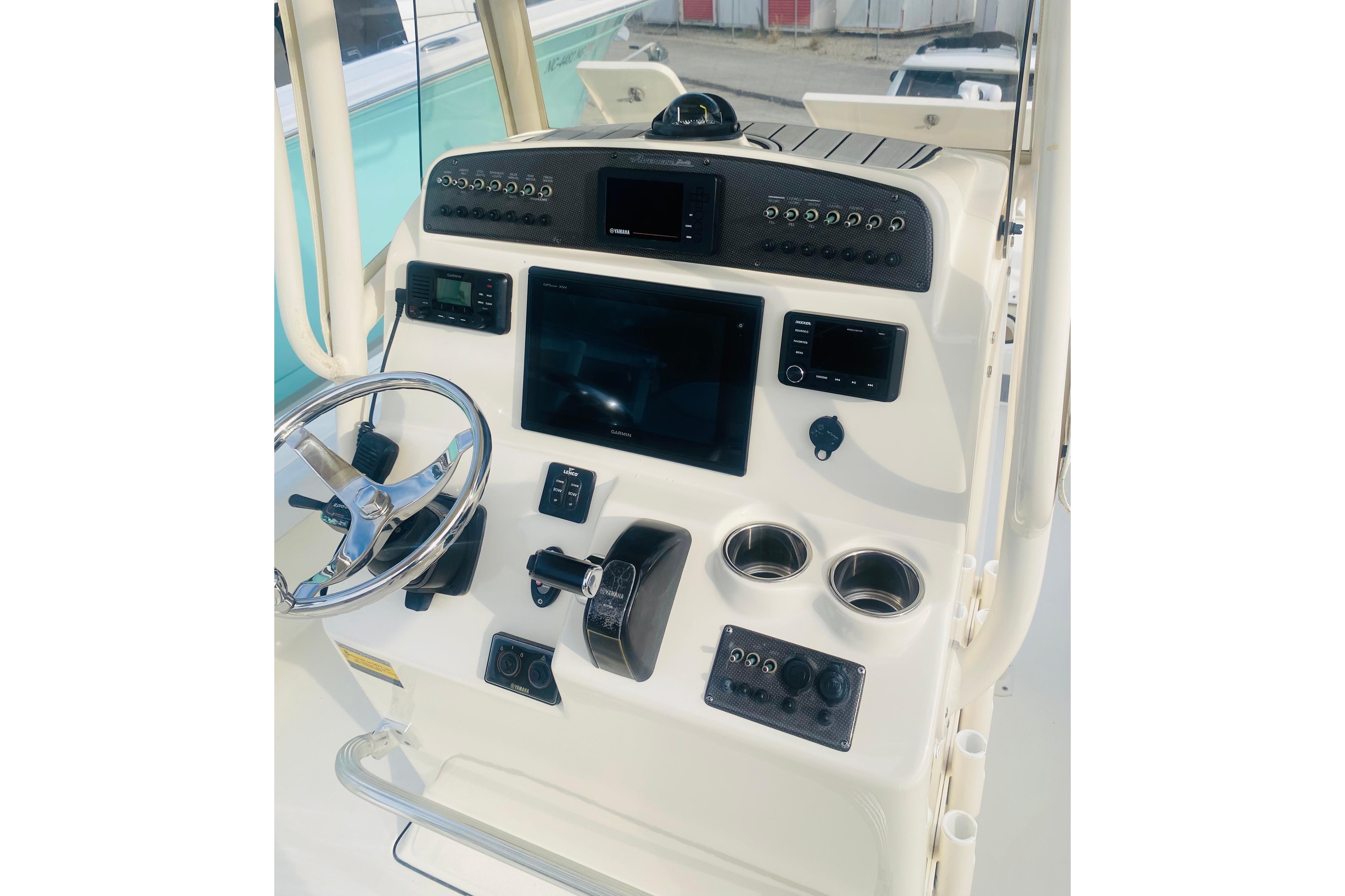 Control panel of 2018 Avenger AV24 boat with steering wheel and electronic displays.
