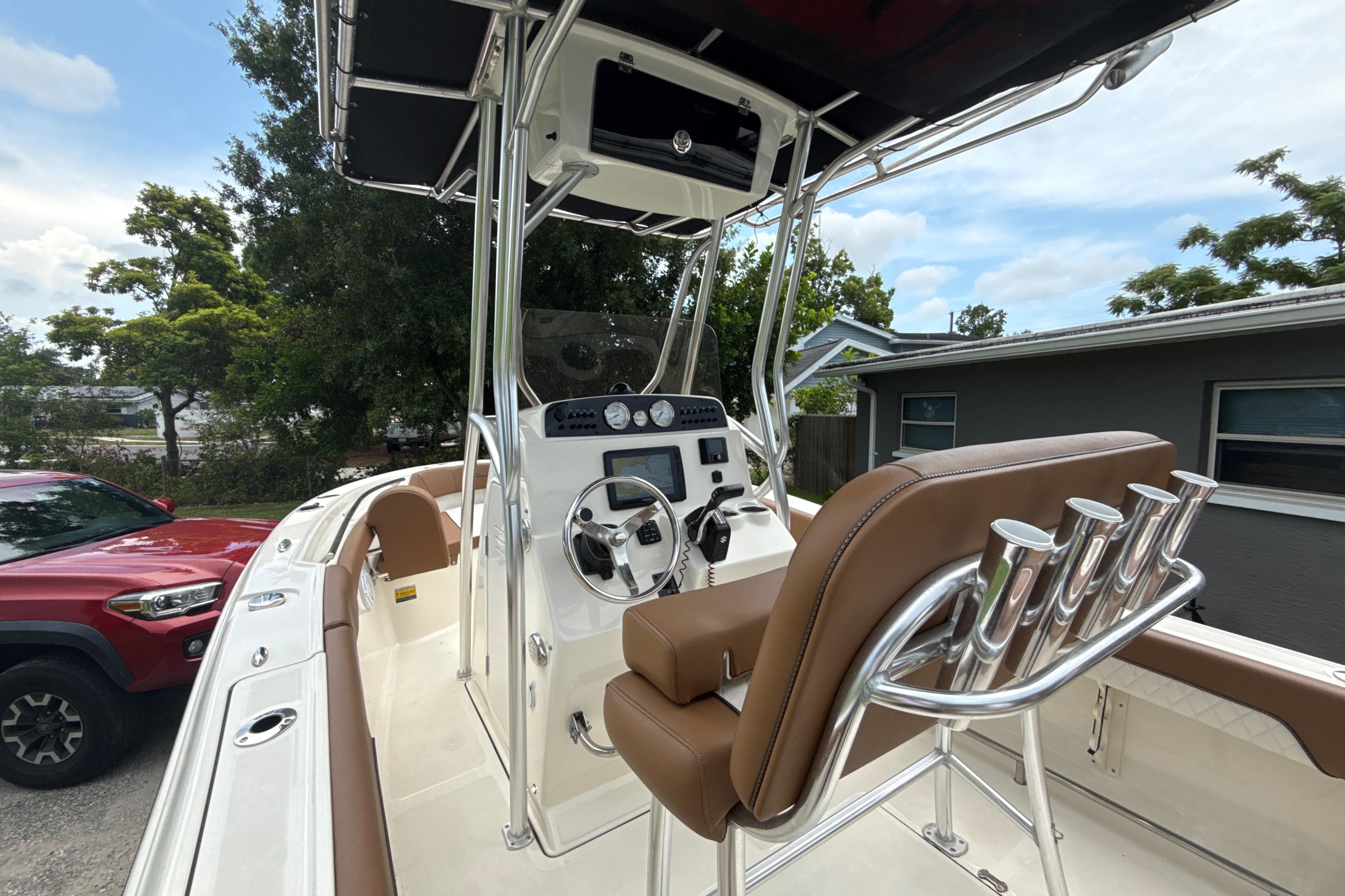 2023 Pioneer 202 Islander boat interior with steering console and seating, parked outdoors.