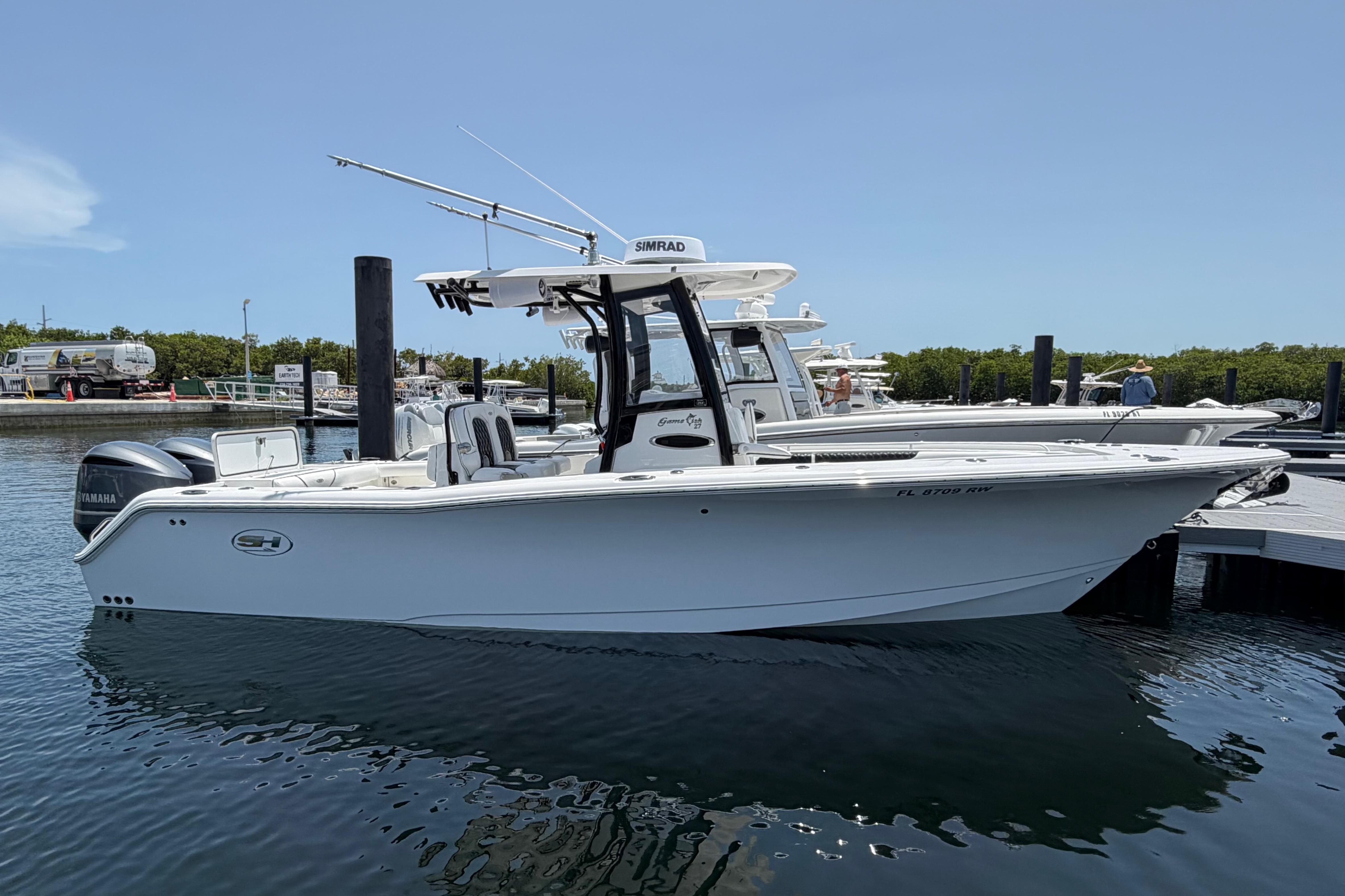 2019 Sea Hunt Gamefish 27 Coffin Box boat docked in marina, clear sky background.