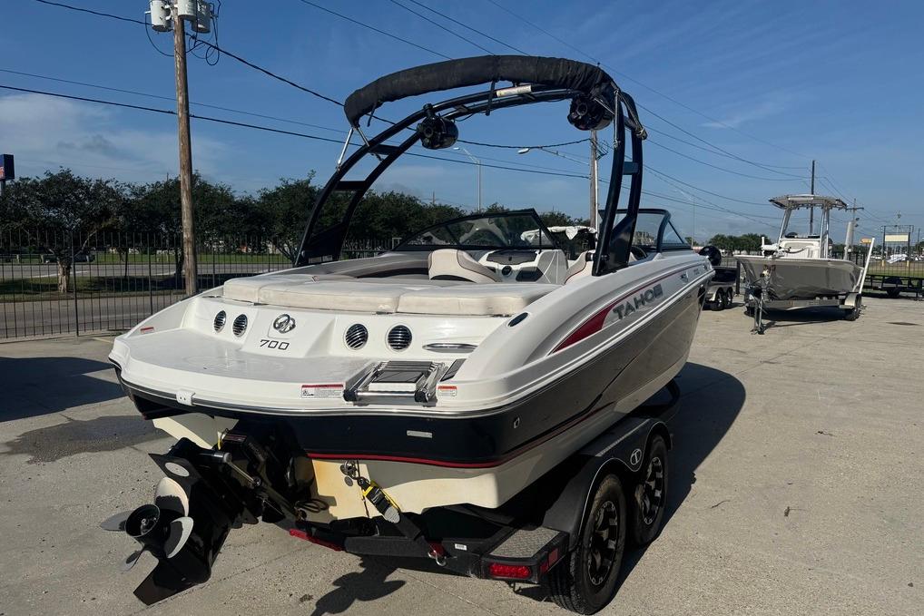 2018 Tahoe 700 TF boat on trailer, parked outdoors under clear blue sky.