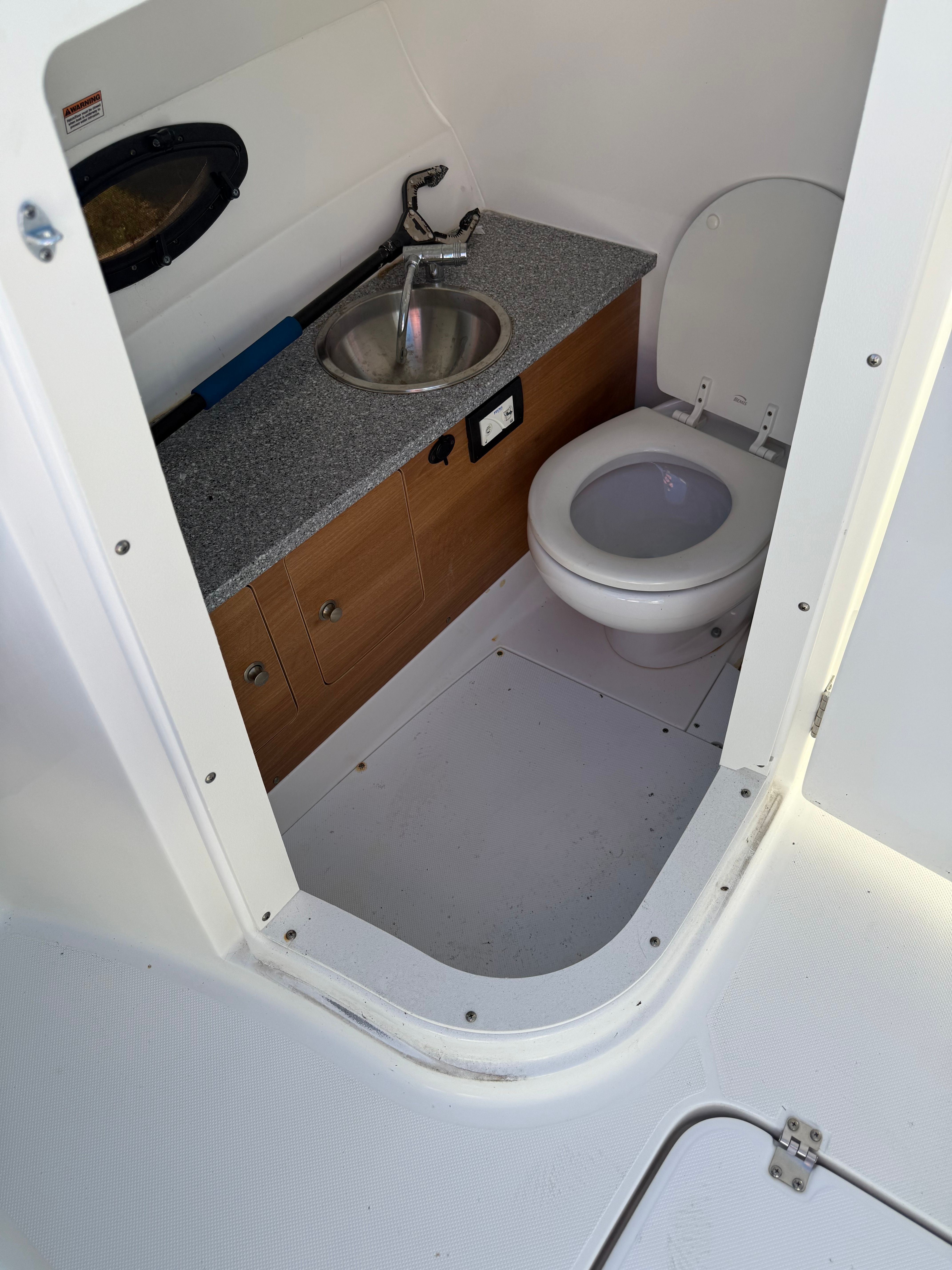Interior of 2018 Hurricane SunDeck 2690 OB with toilet and sink.