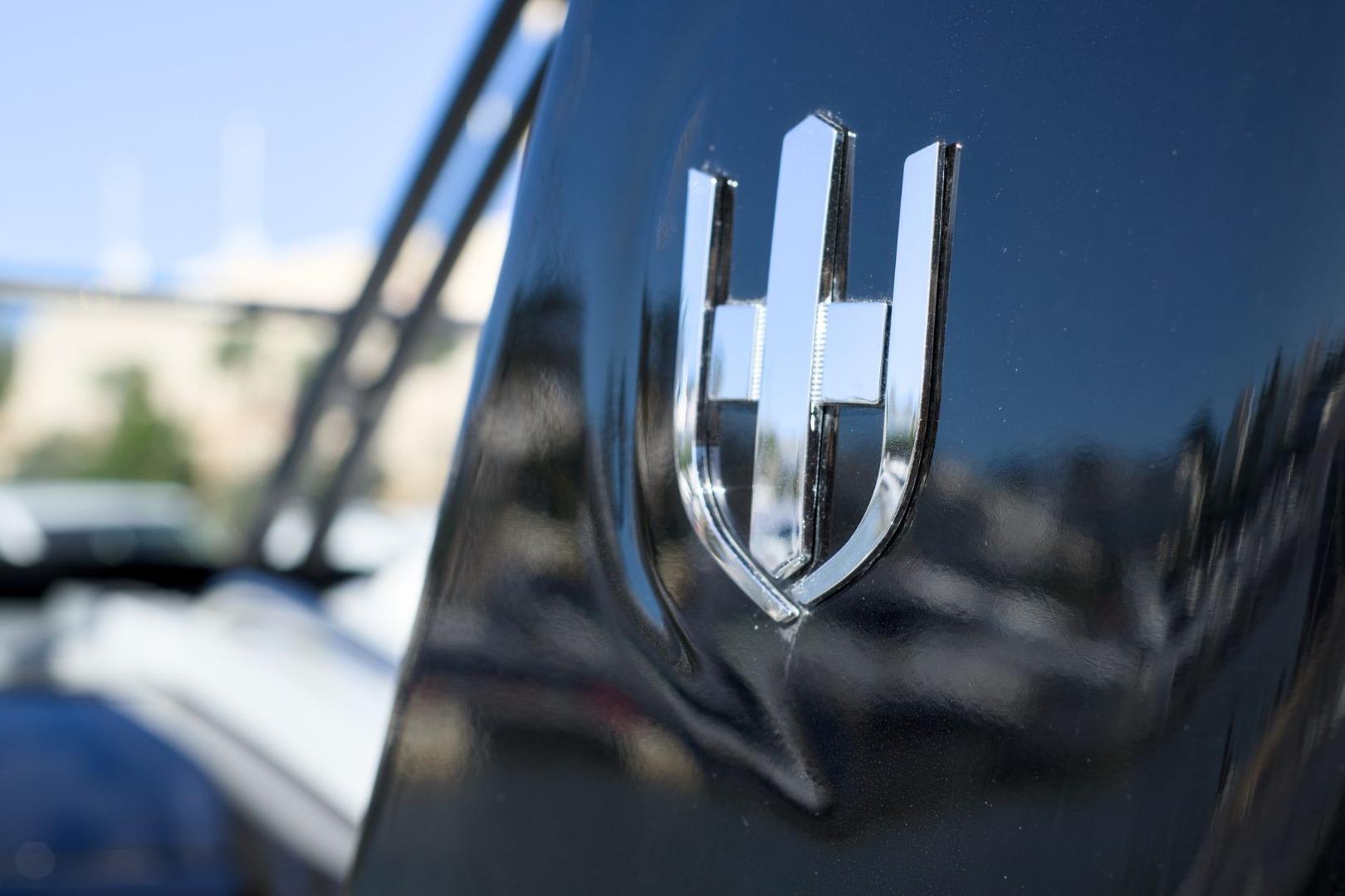 Close-up of 2023 Invictus GT320 logo on sleek black surface.