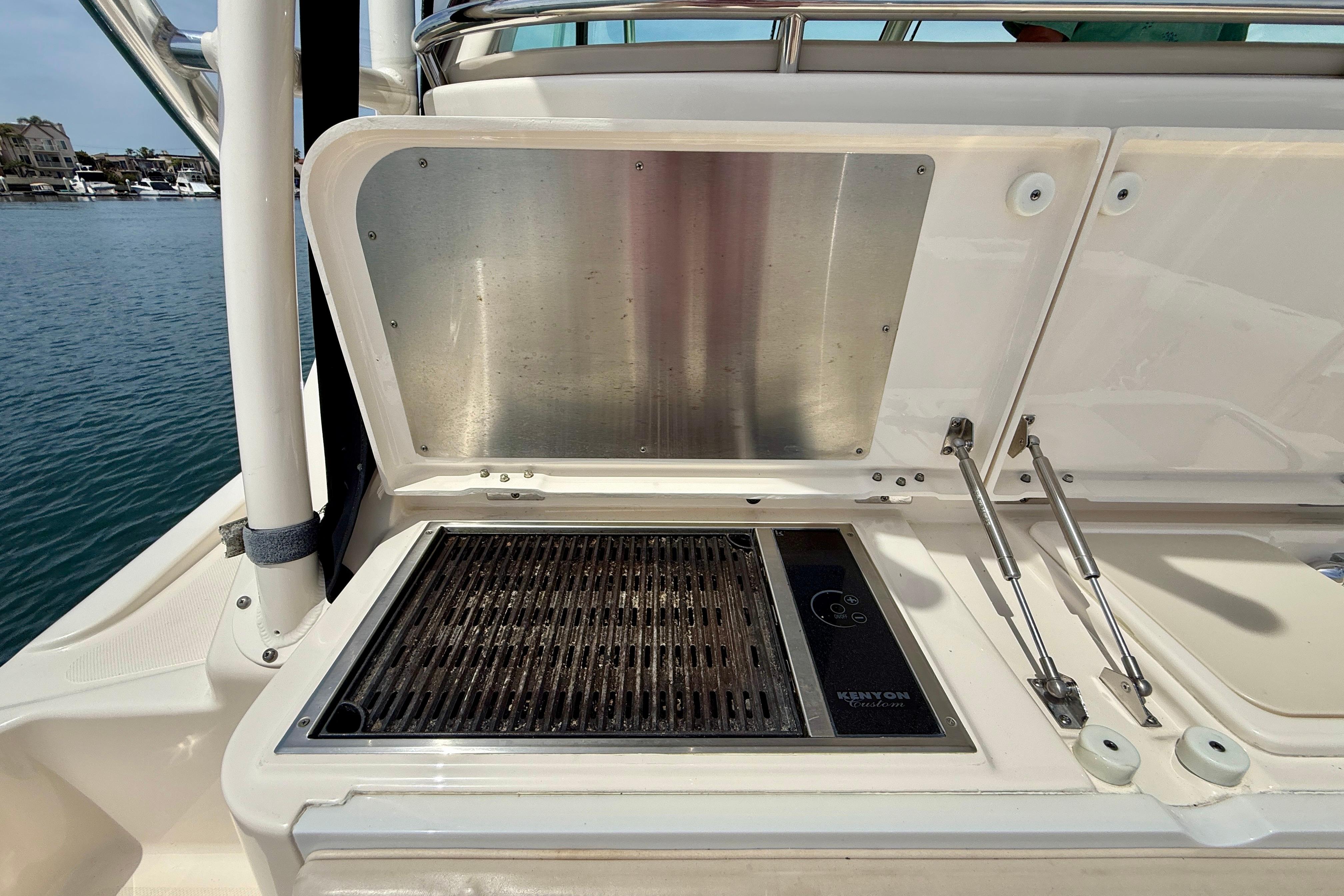 Outdoor grill on a 2012 Pursuit OS 345 Offshore boat, docked by the water.