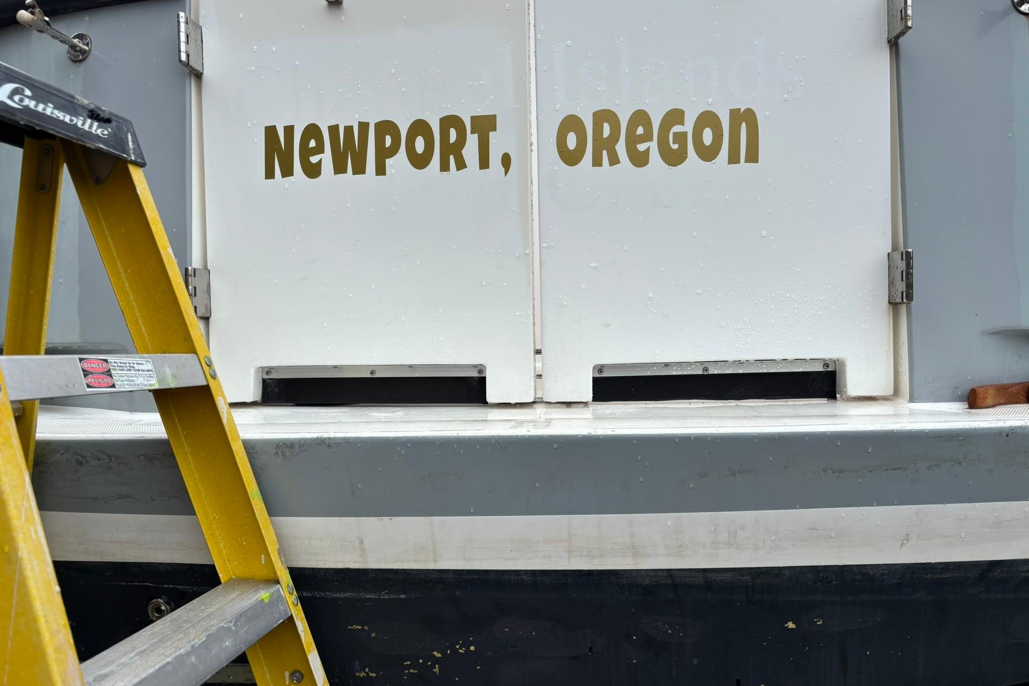 Yellow ladder beside SeaPiper 35 boat with "Newport, Oregon" text.